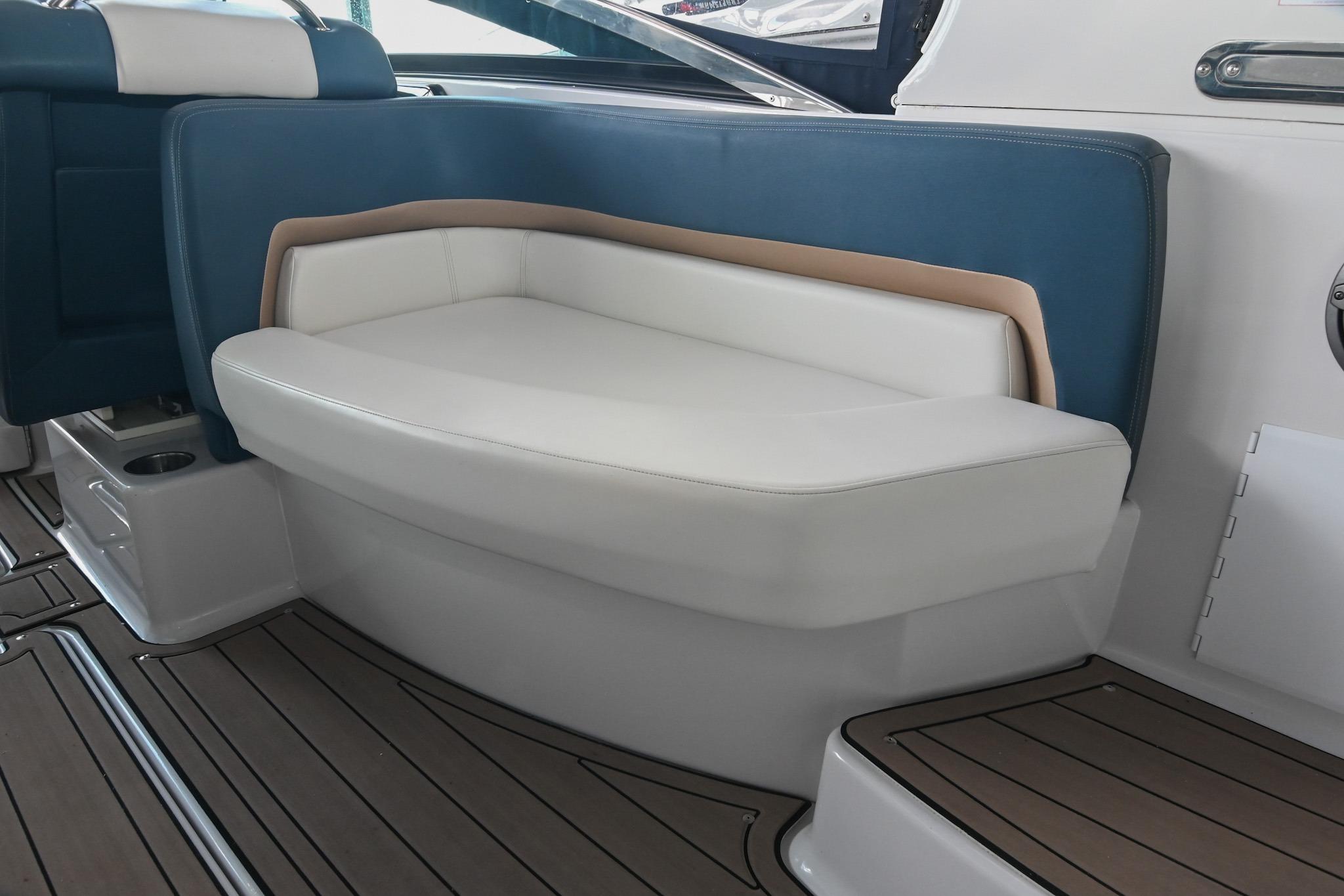 2014 Four Winns H290 boat interior with cushioned seating and wood-style flooring.