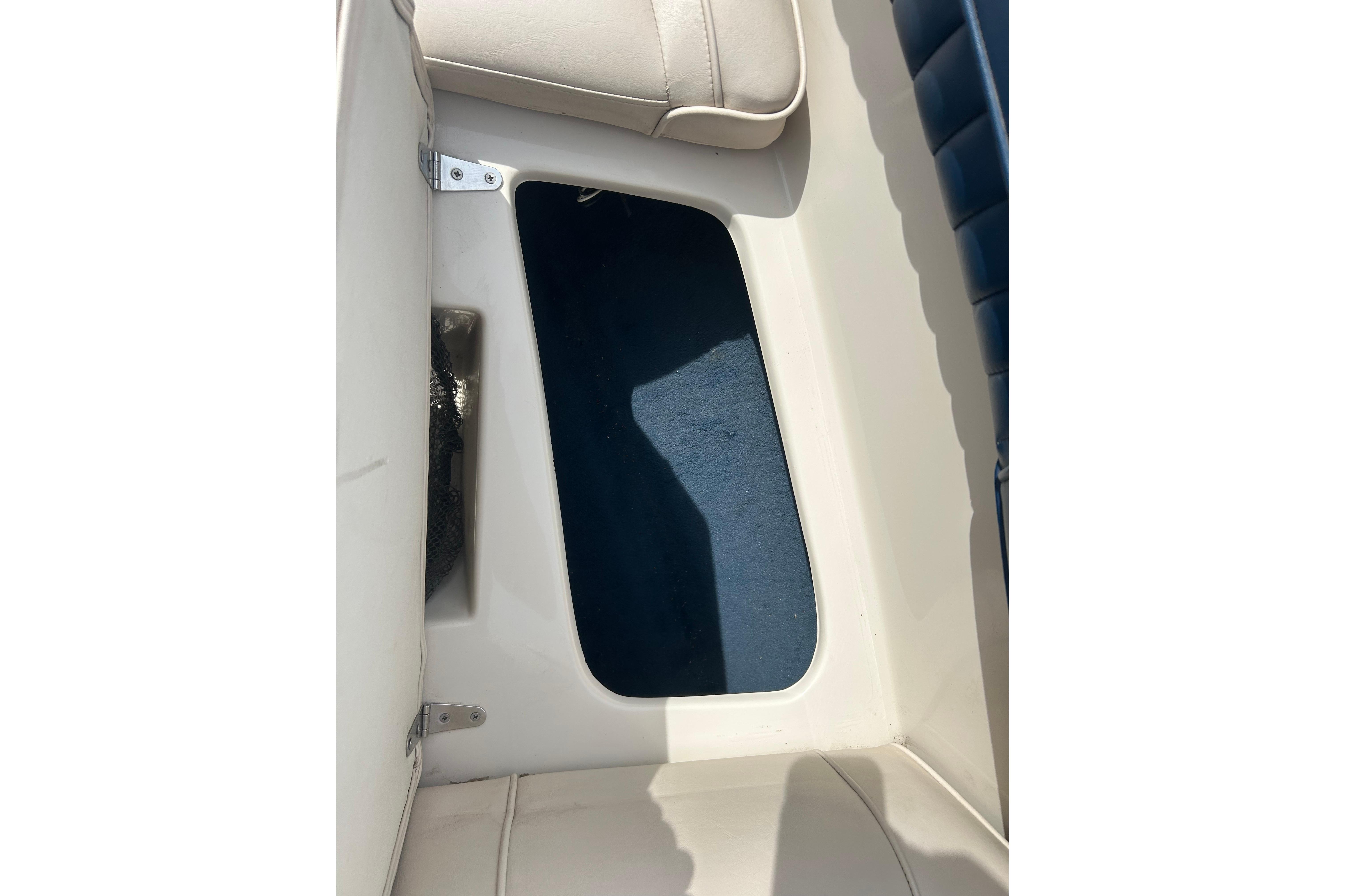 Interior view of a 1996 Mariah 180 Shabah boat, featuring beige seating and blue flooring.