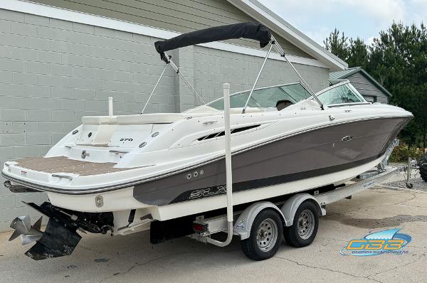 2008 Sea Ray 270 SLX boat on trailer, parked outdoors near a building.