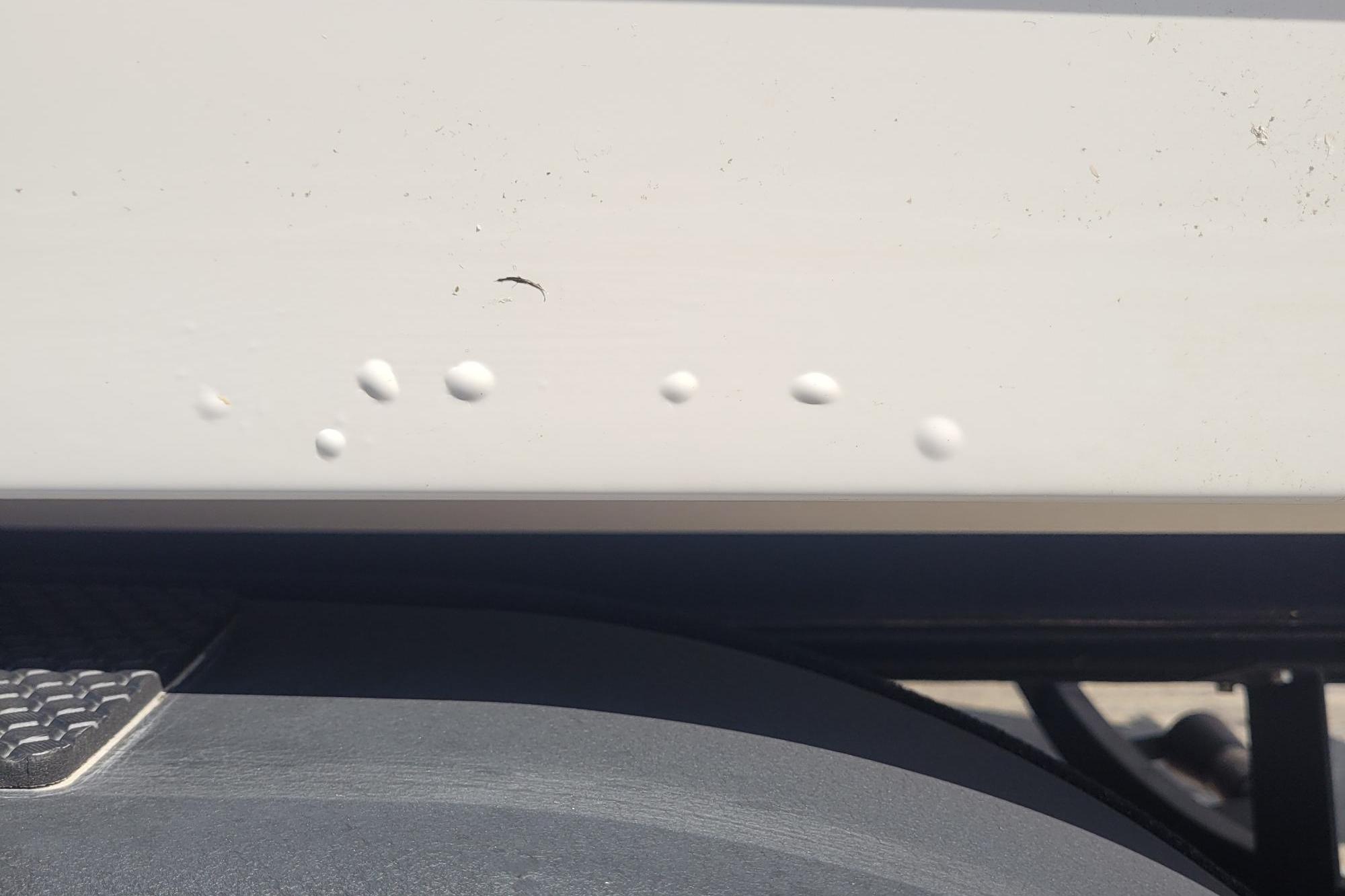 Close-up of 2024 Tahoe 1950 vehicle with paint imperfections on the body.