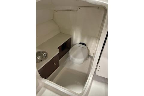2022 Robalo R247 Dual Console boat interior with compact bathroom amenities.