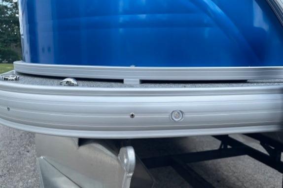2026 Sun Tracker Fishin' Barge 20 DLX pontoon boat, close-up of blue exterior and railing.