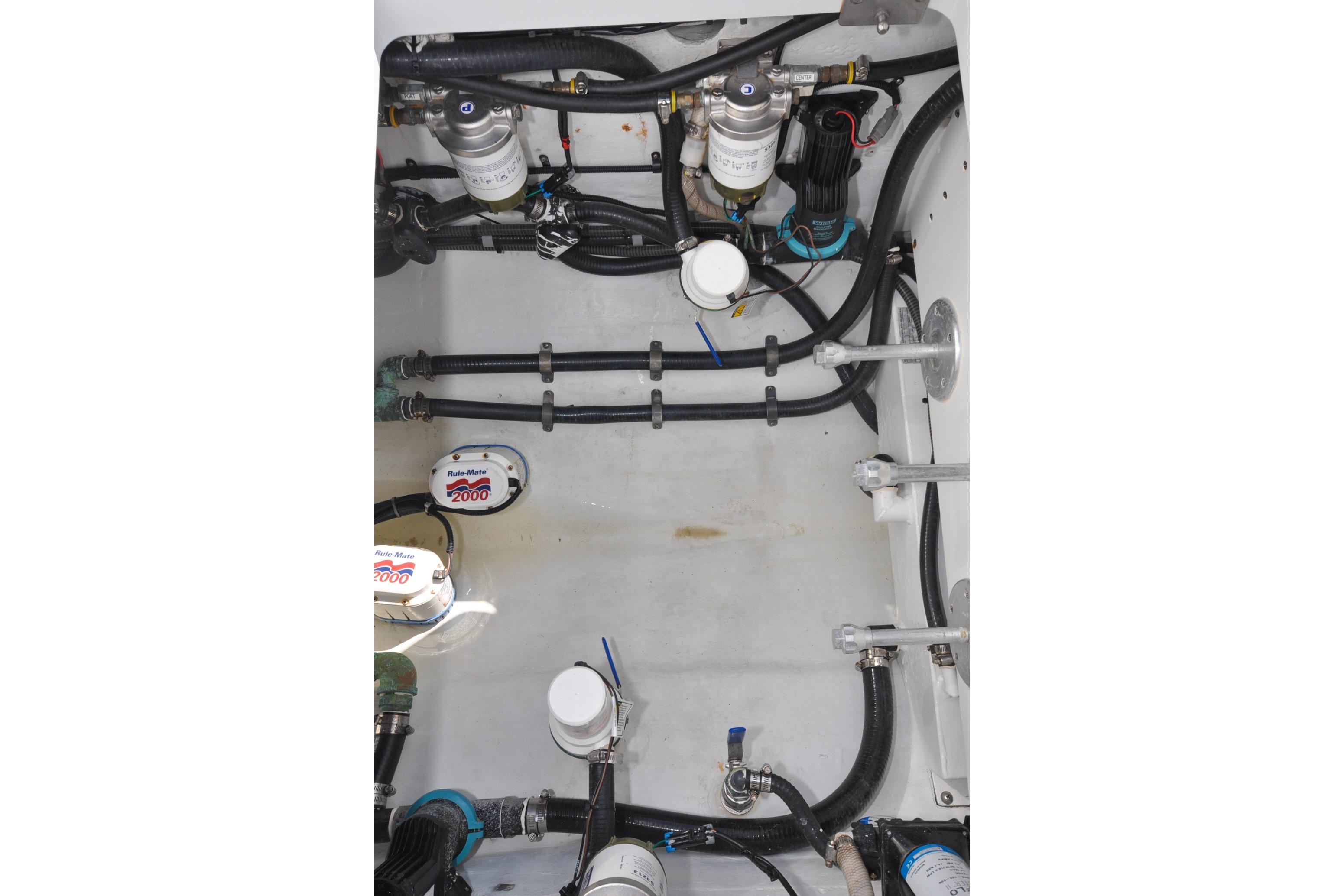 Engine compartment of a 2011 Yellowfin 39 Offshore boat, showcasing pumps and hoses.