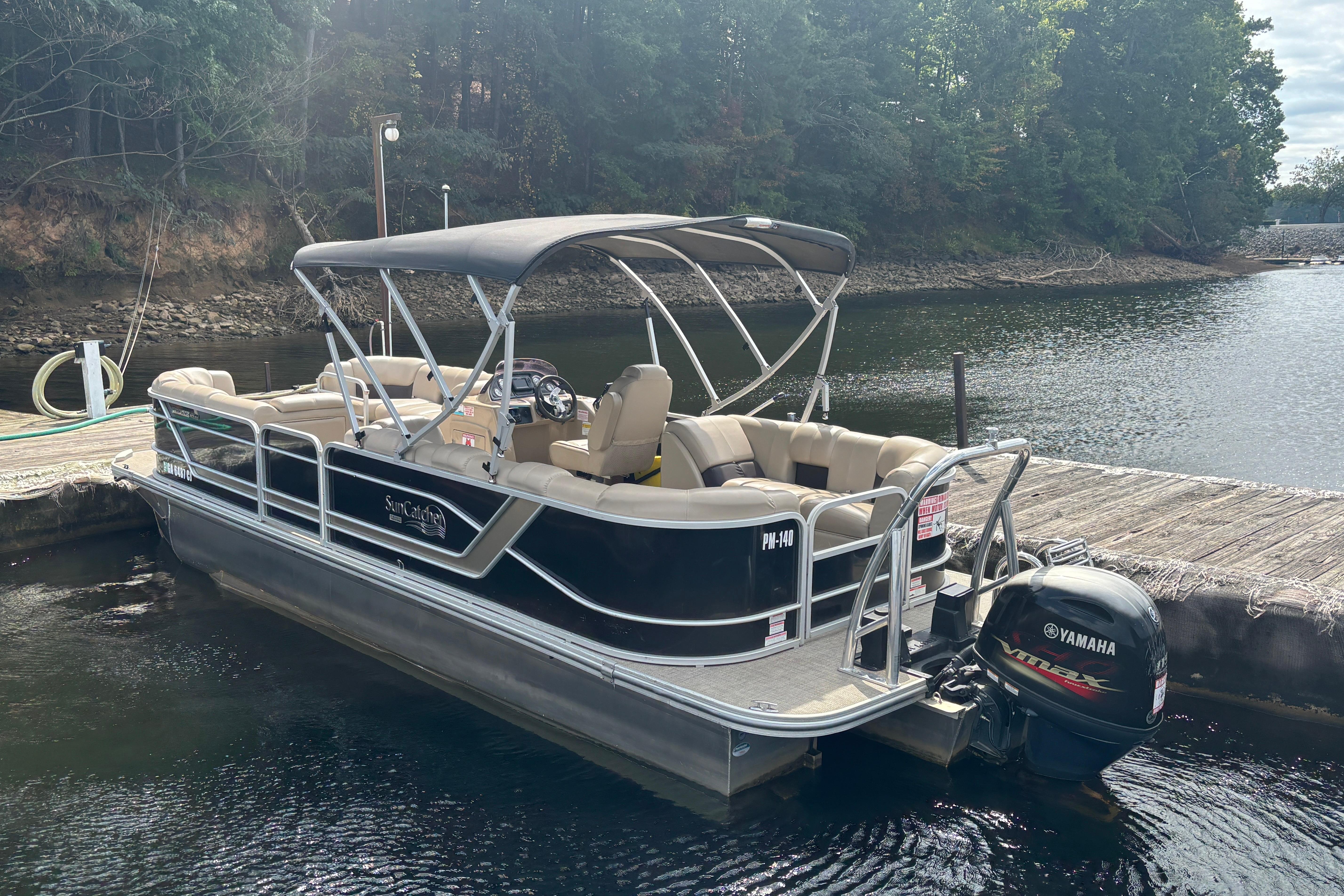2021 SunCatcher Fusion 325RCX pontoon boat docked on a serene lake.