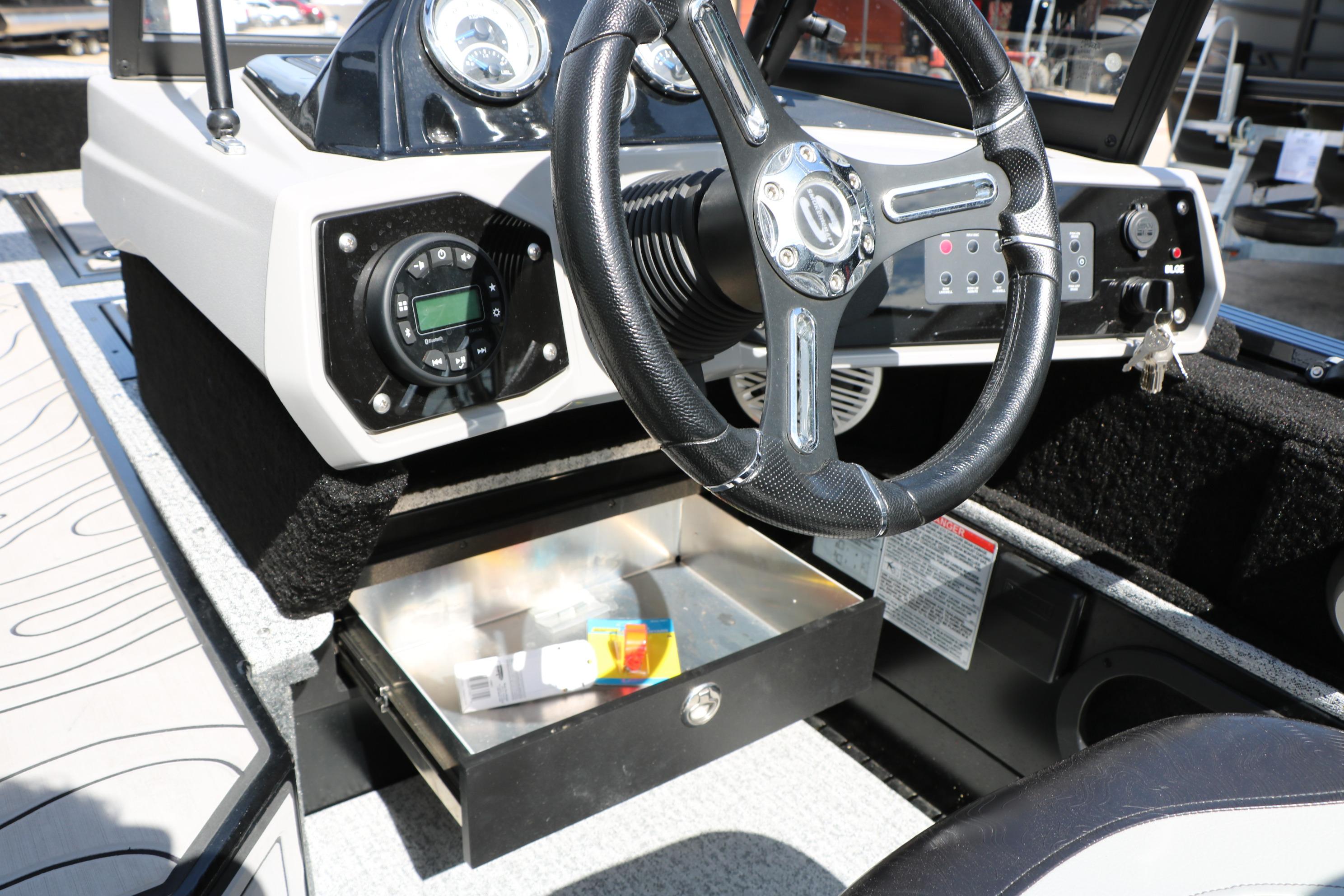 2025 Smoker Craft Adventurer 188 DC boat dashboard with steering wheel and open storage compartment.