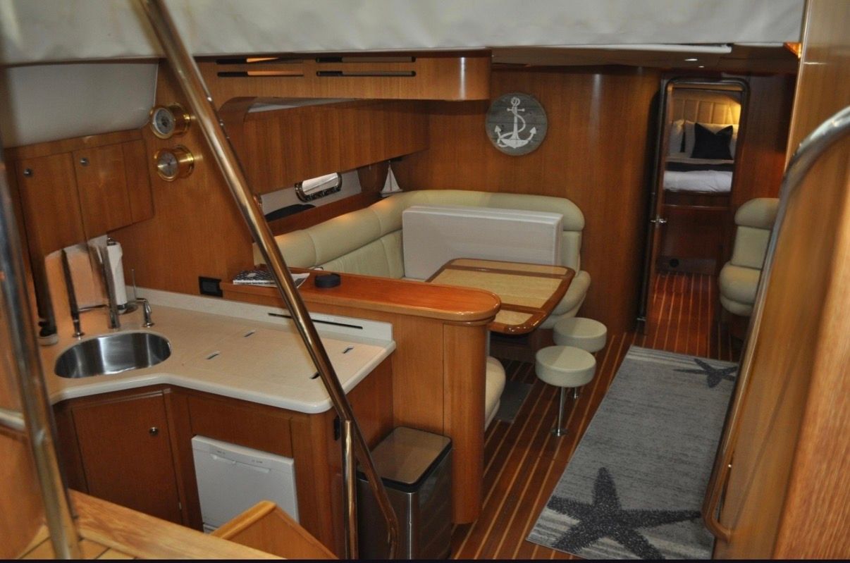 Interior of a 2005 Tiara Yachts 5200 Sovran with wood furnishings and a seating area.