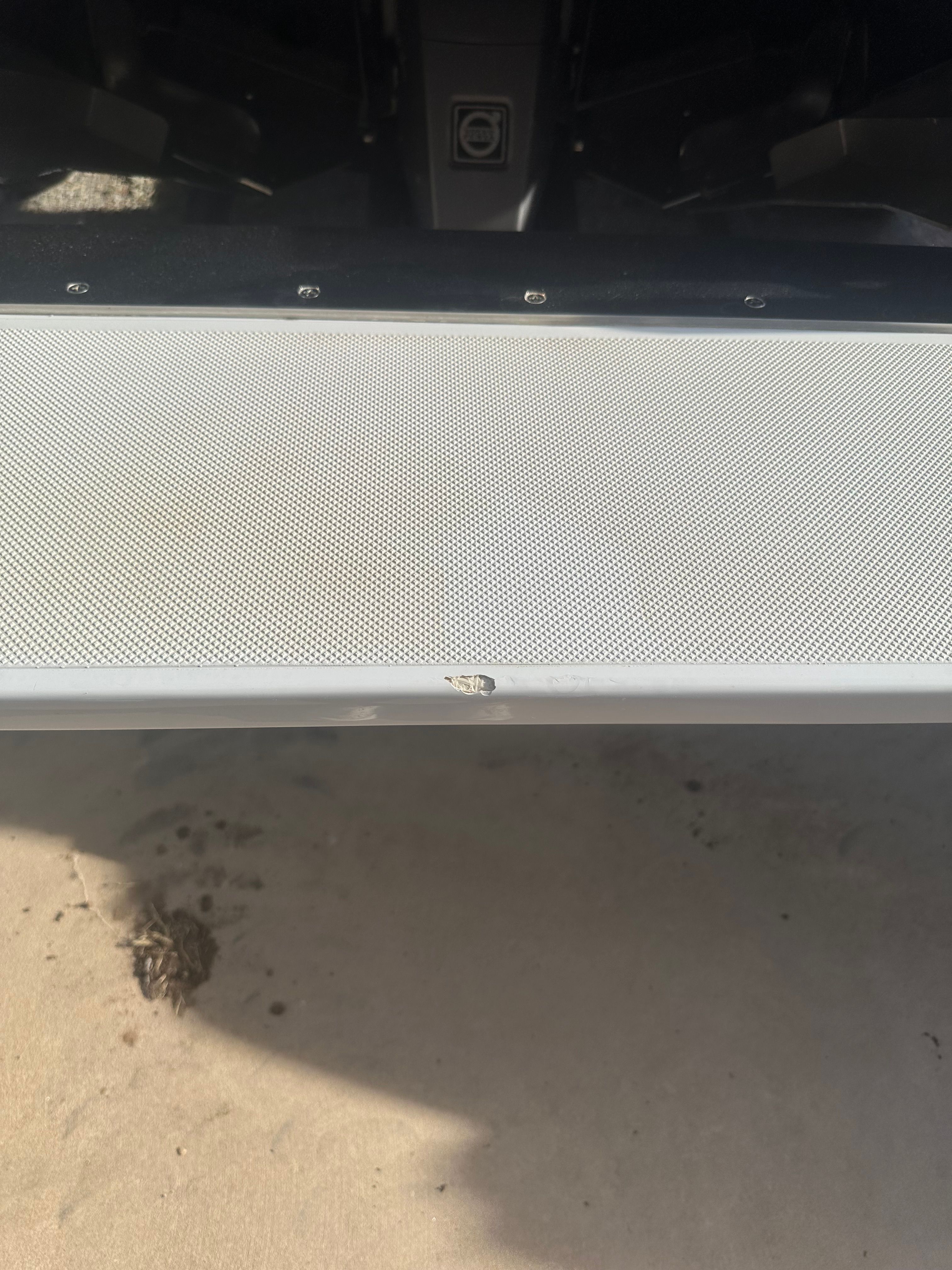 Close-up of a part of a 2019 Cobalt R7 Surf boat, on a concrete floor.