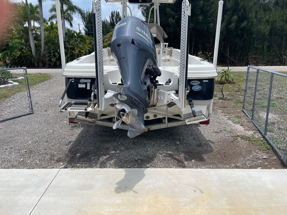 A 2015 NauticStar 231 Coastal boat with a Yamaha outboard motor, parked on a concrete area.