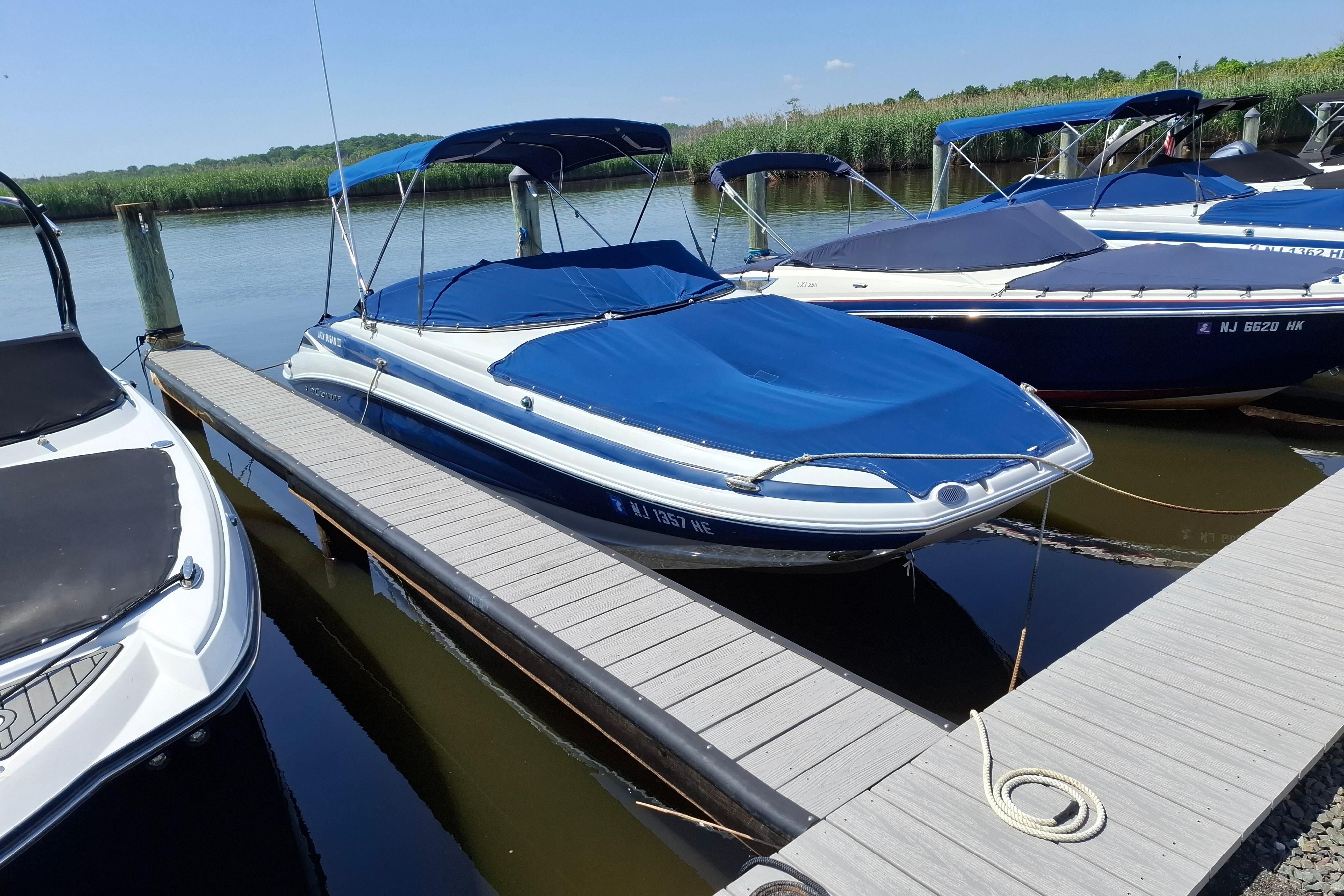 2013 Crownline Eclipse E6 boat docked with blue cover and canopy.