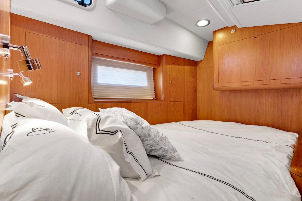 Luxurious cabin interior of 2011 Southerly 57 RS yacht with cozy bedding.