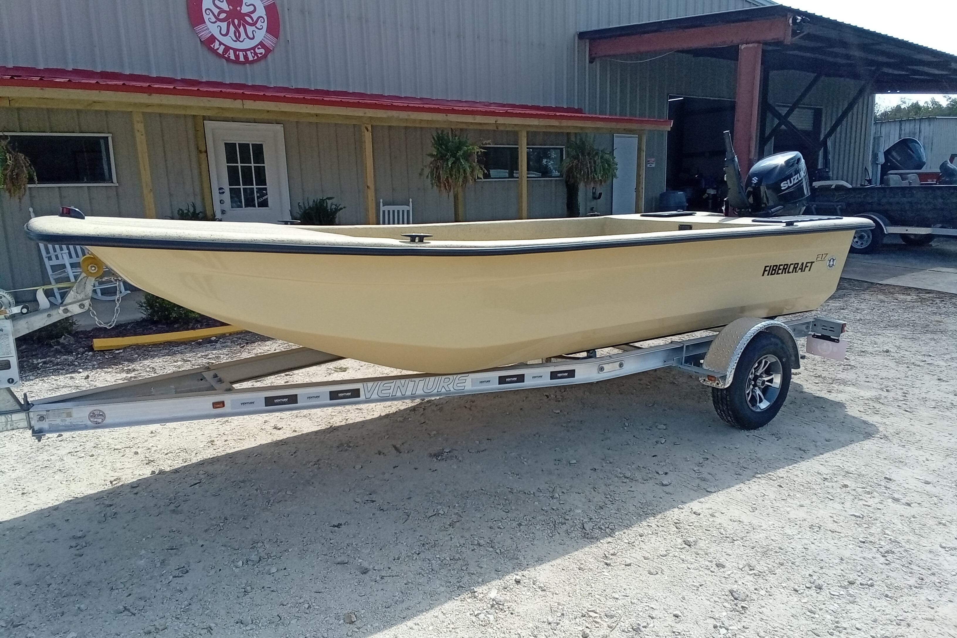 2025 Fibercraft F17 boat on trailer outside a building.