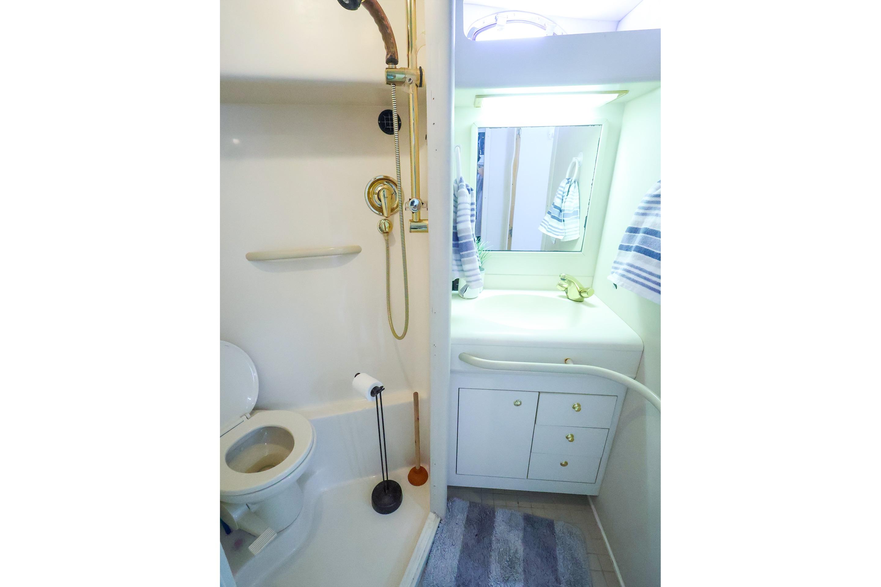 Bathroom interior of 1998 Sea Ray 500 Sundancer yacht, featuring shower and vanity.