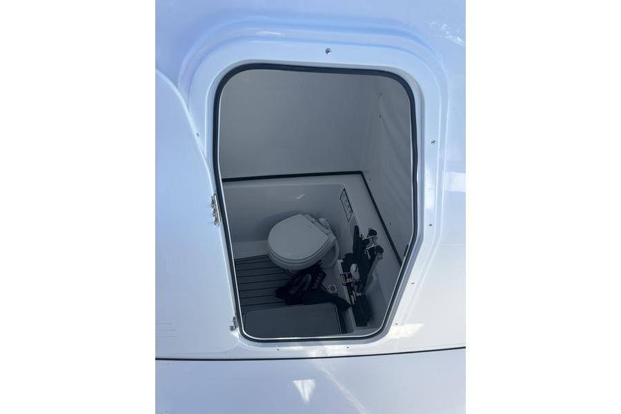 2026 Sportsman Open 282 Center Console boat interior with compact marine toilet.