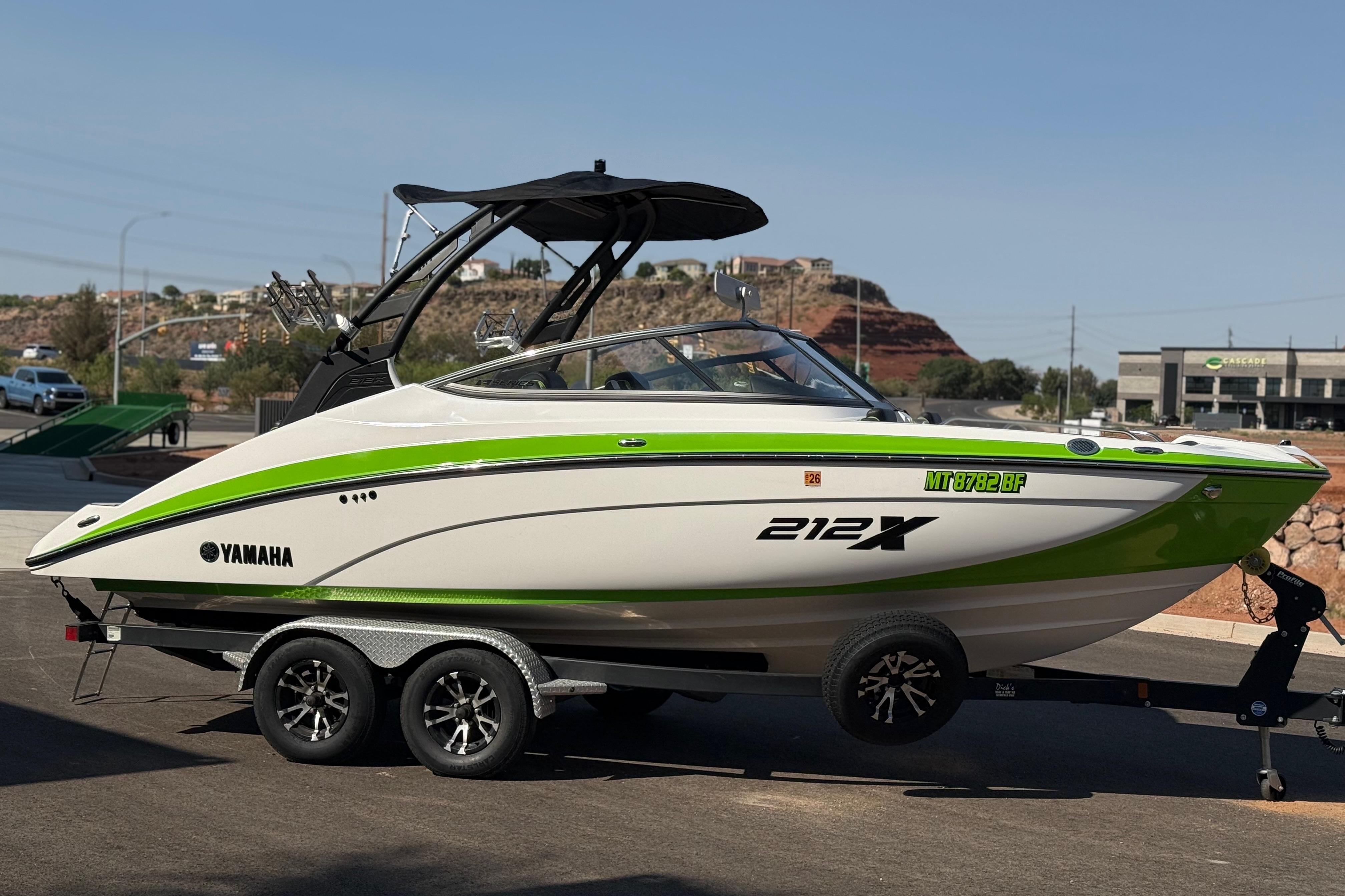 2022 Yamaha Boats 212XE on trailer, featuring sleek design and vibrant green accents.