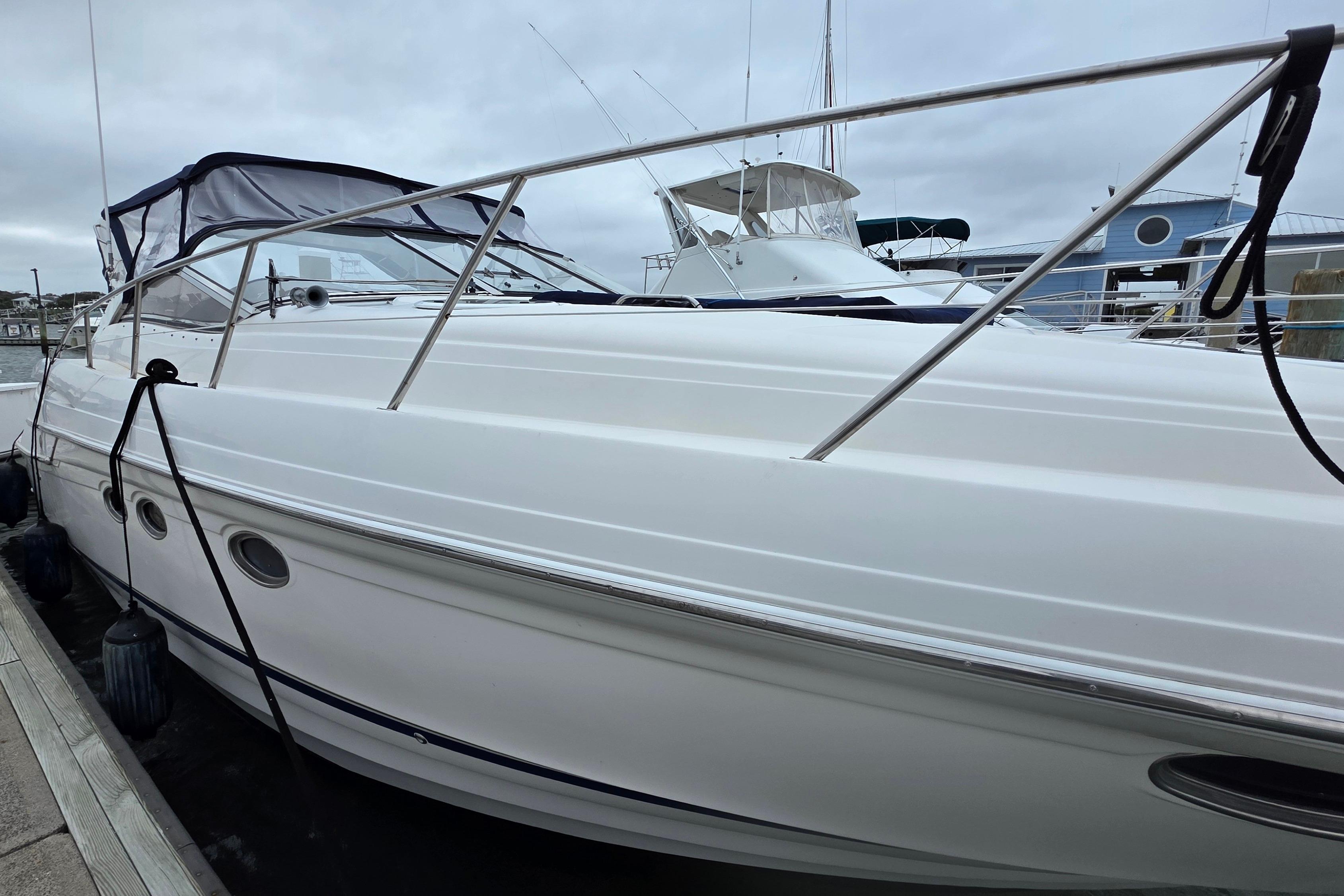 2002 Regal Commodore 4260 yacht docked at marina under cloudy sky.