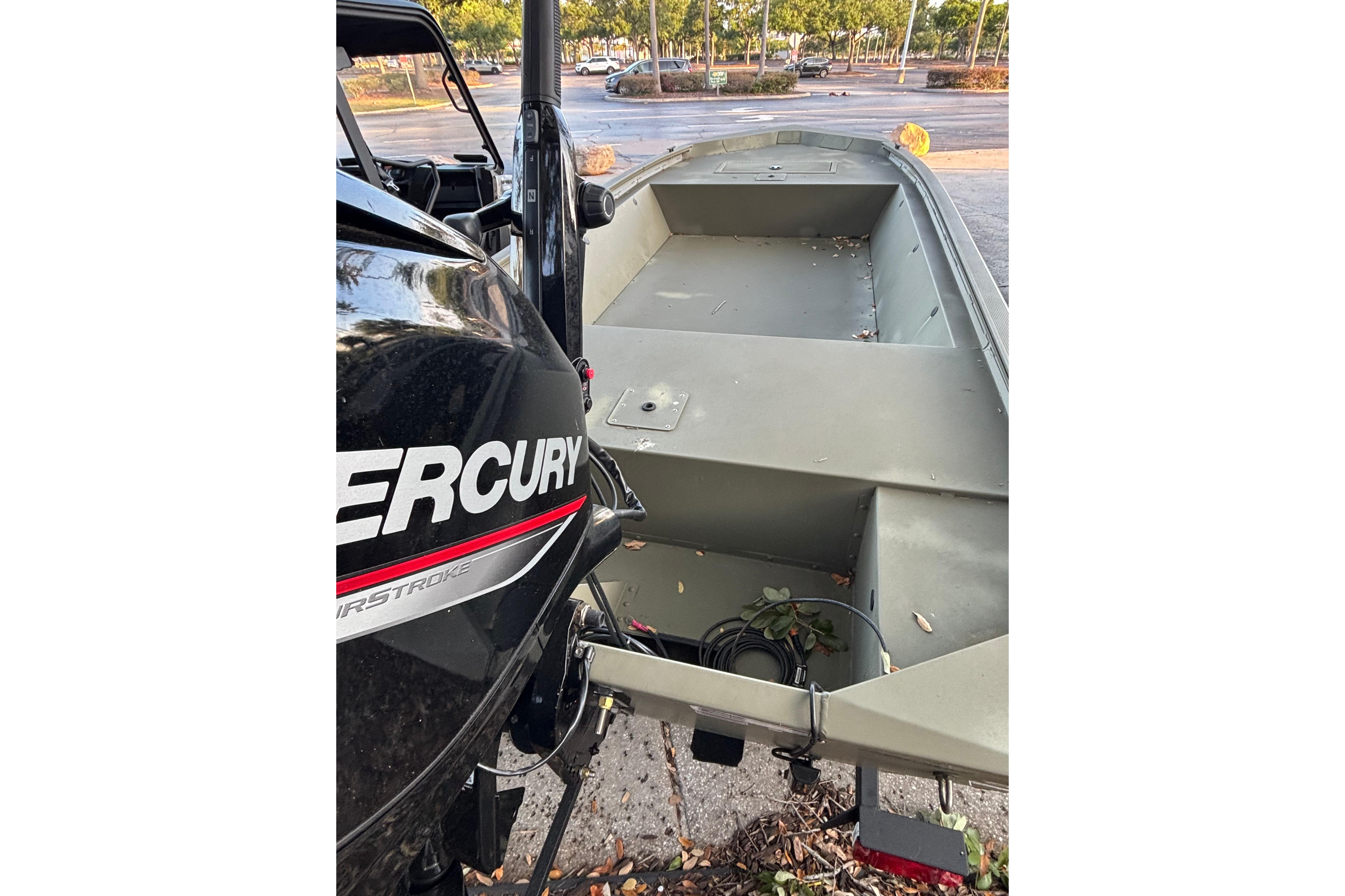 2025 Tracker Grizzly 1648 Jon boat with Mercury engine in a parking lot.
