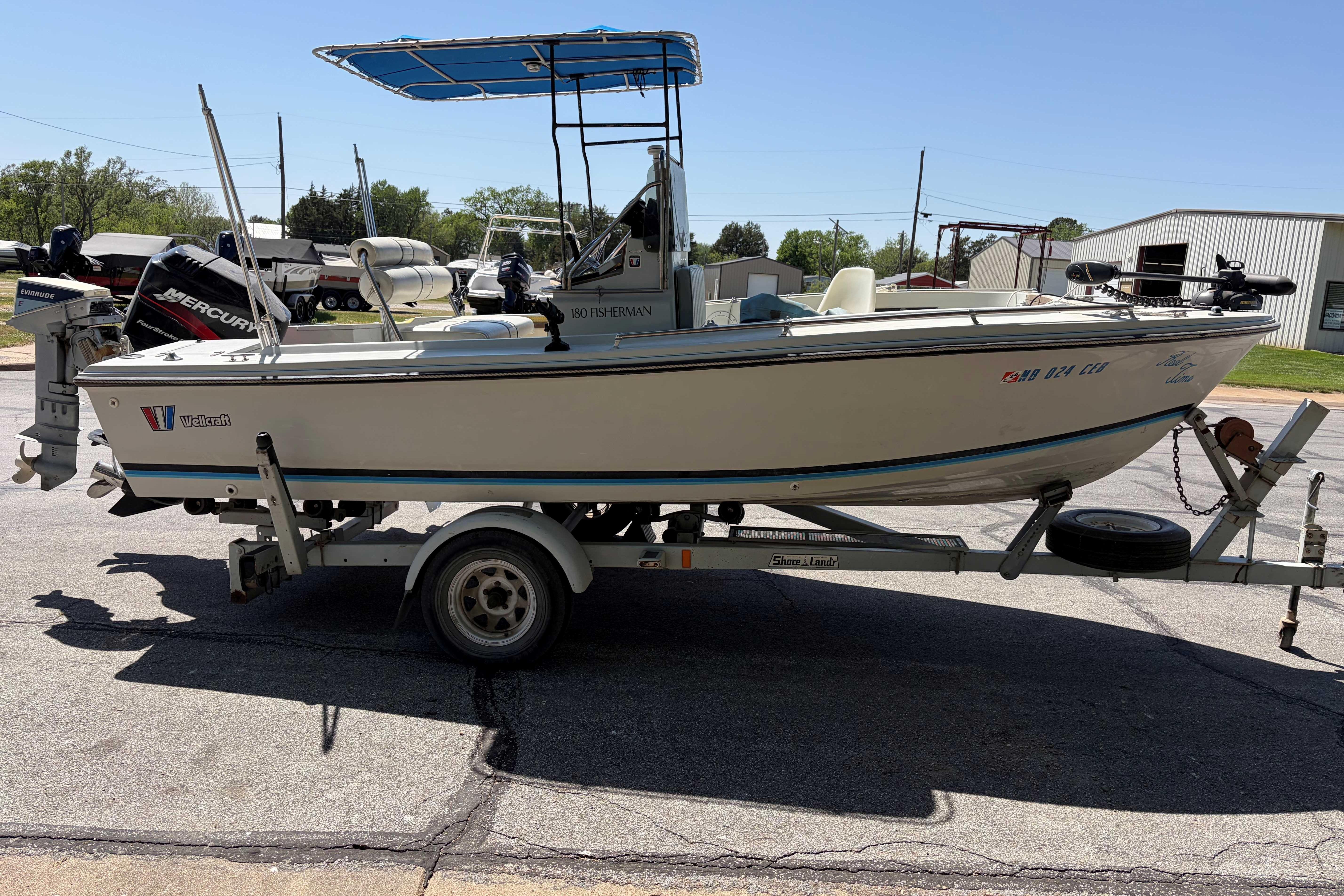 1985 Wellcraft 180 Fisherman boat on trailer, parked outdoors under clear sky.