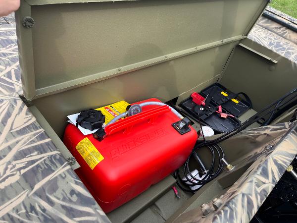 2024 Lowe Roughneck 1660 storage compartment with red fuel tank and battery.