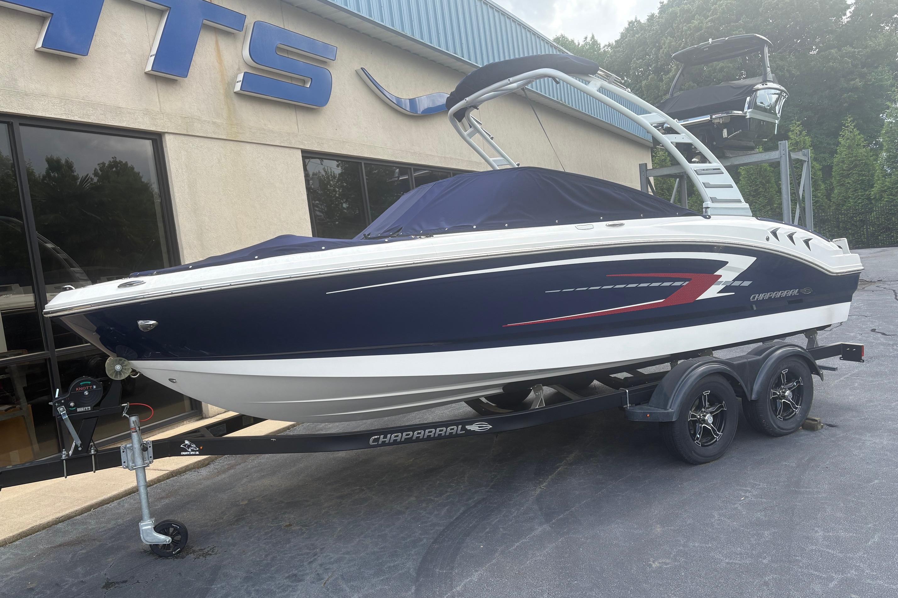 2025 Chaparral 21 SSi boat on trailer, parked outside dealership.