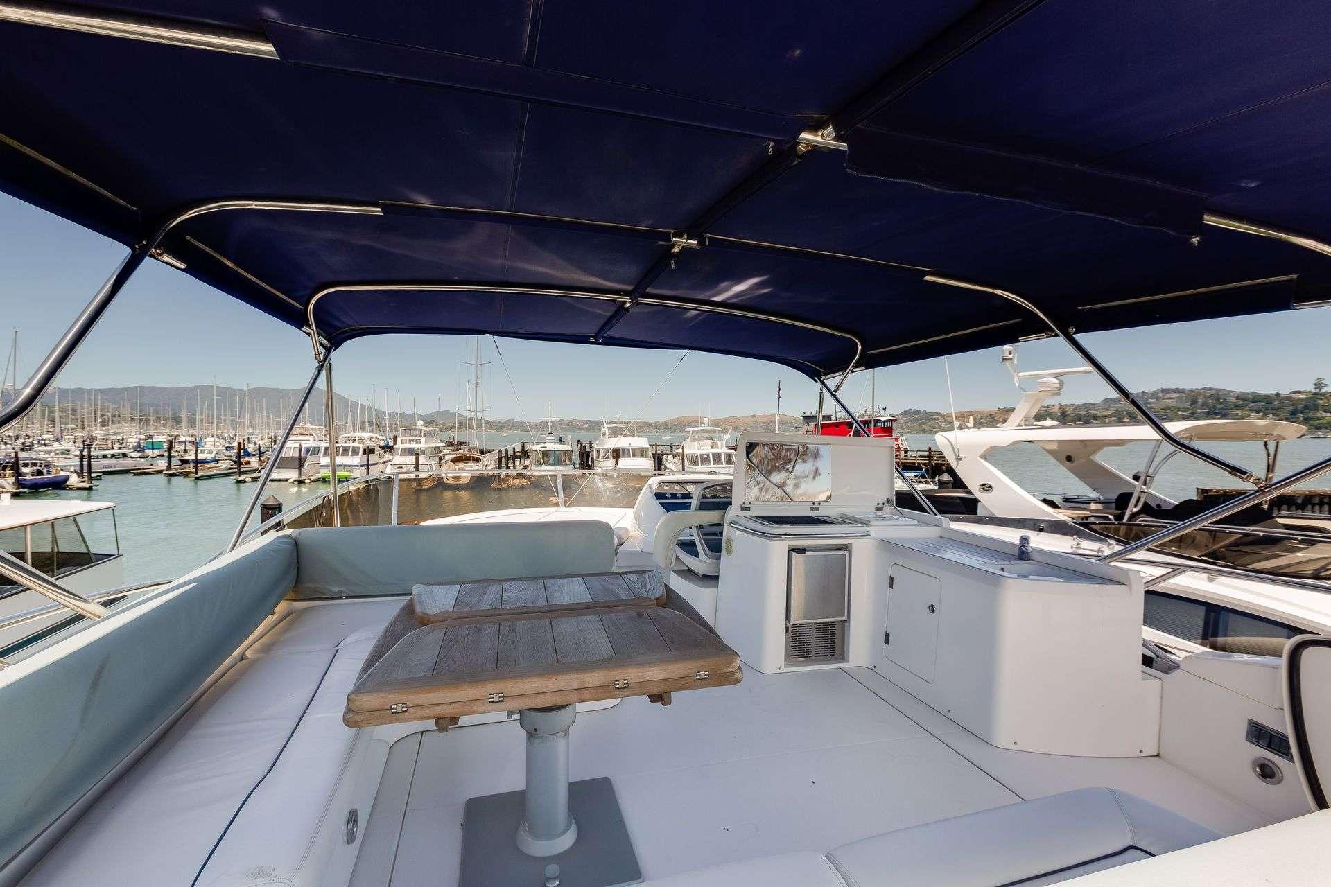 2009 Sunseeker Manhattan 70 yacht interior with seating and table, docked at marina.