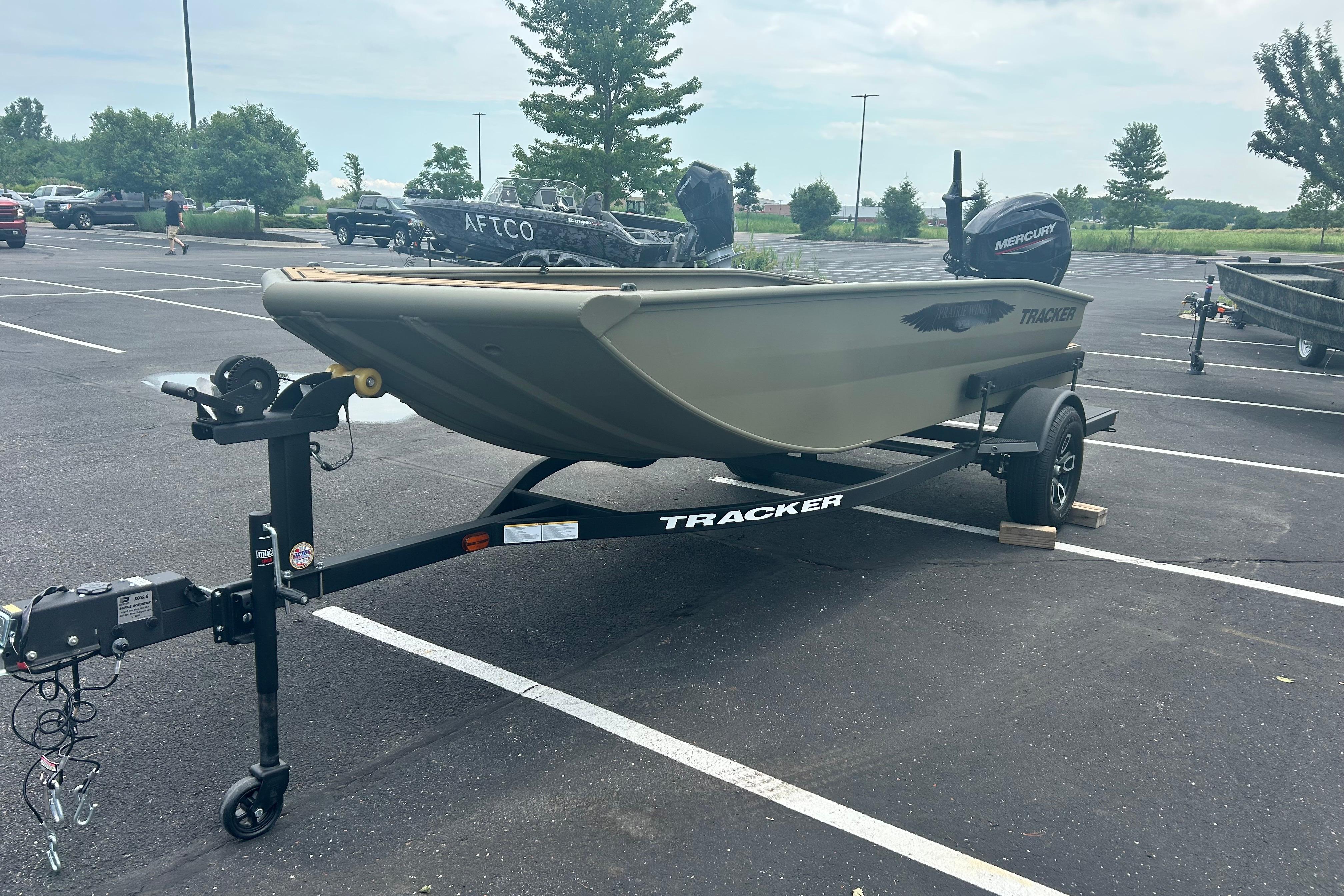 2026 Tracker Grizzly 1650 T Prairie Wings Edition boat on trailer in parking lot.