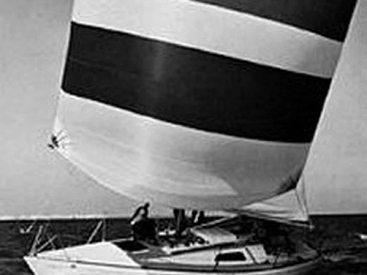 A sailboat with a striped sail on the water.