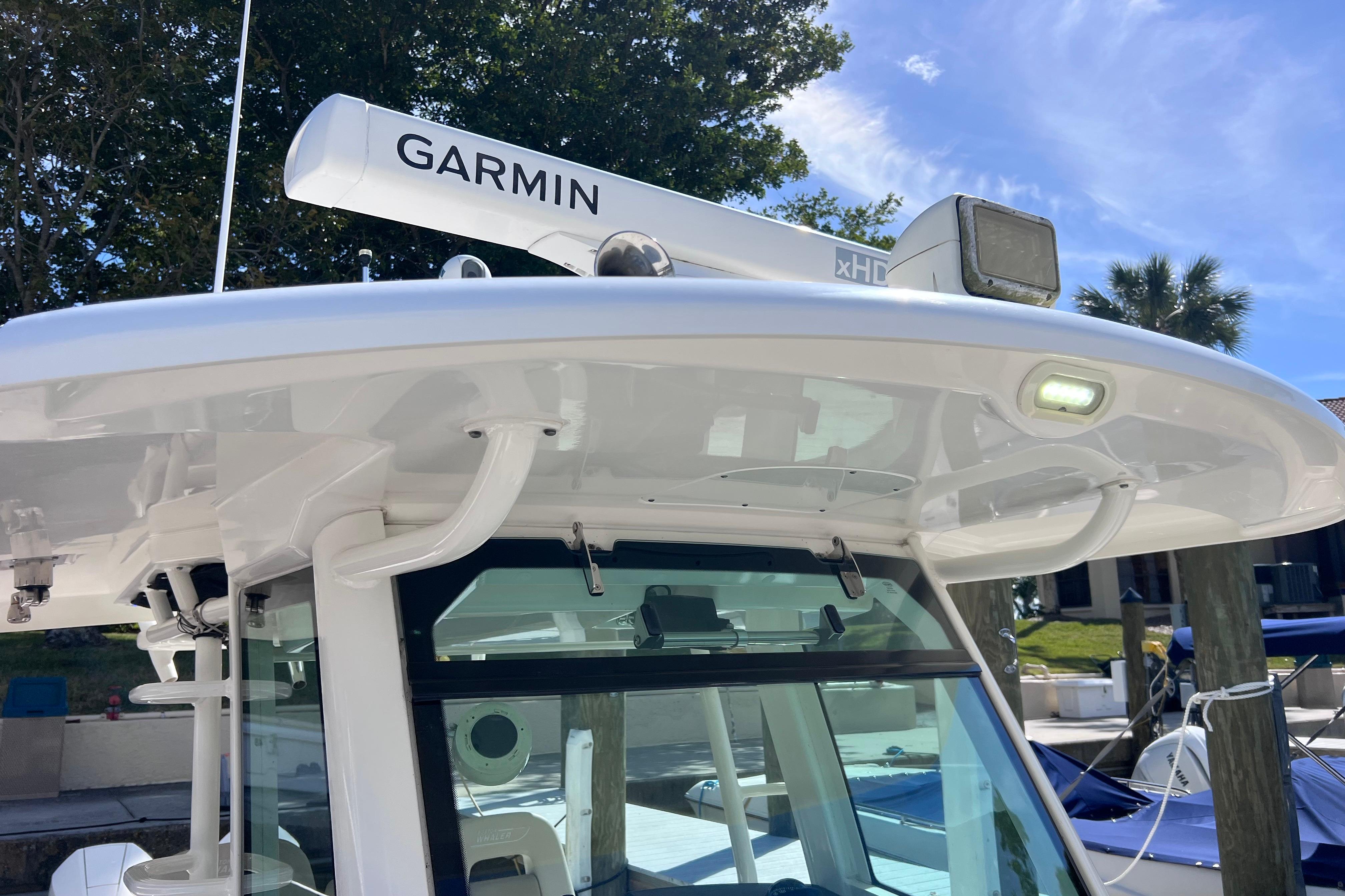 2021 Boston Whaler 330 Outrage with Garmin radar, docked under clear blue sky.