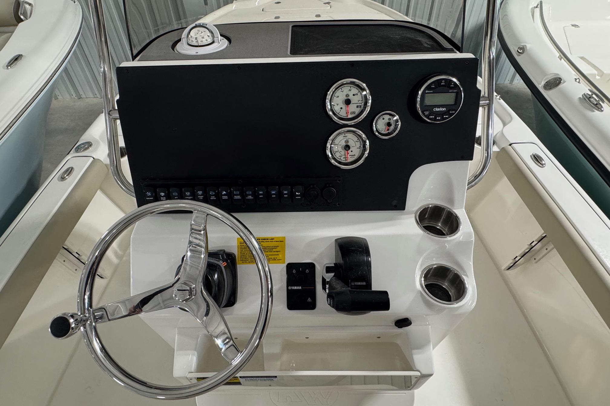 Steering console of 2026 Key West 210 Bay Reef boat with gauges and controls.