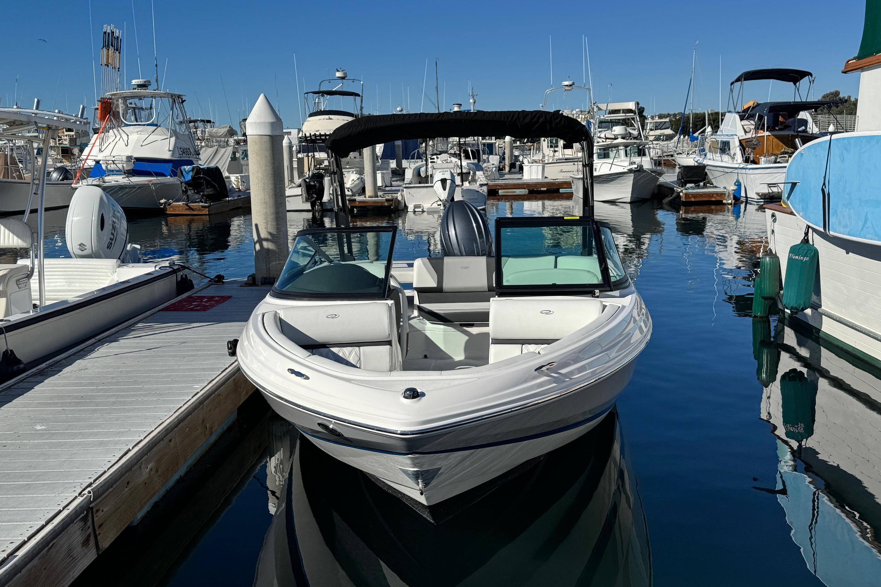 2026 Regal 21 OBX boat docked at a marina, surrounded by other vessels.