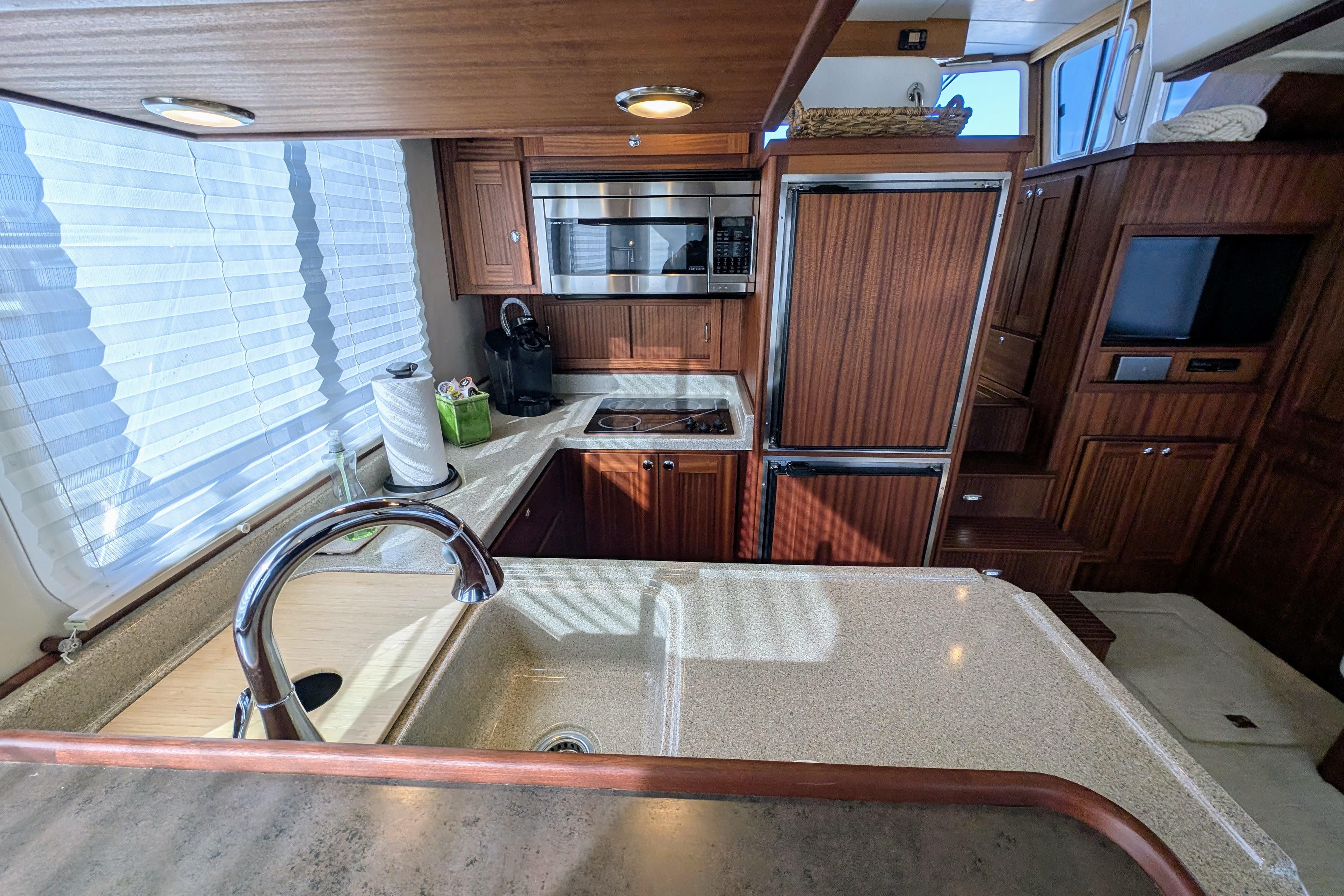 Luxurious kitchen interior of 2015 American Tug 435 with modern appliances and wood cabinetry.