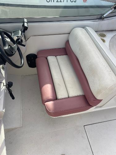 1992 Regal Ventura boat interior with white and pink seating, steering wheel, and cup holders.