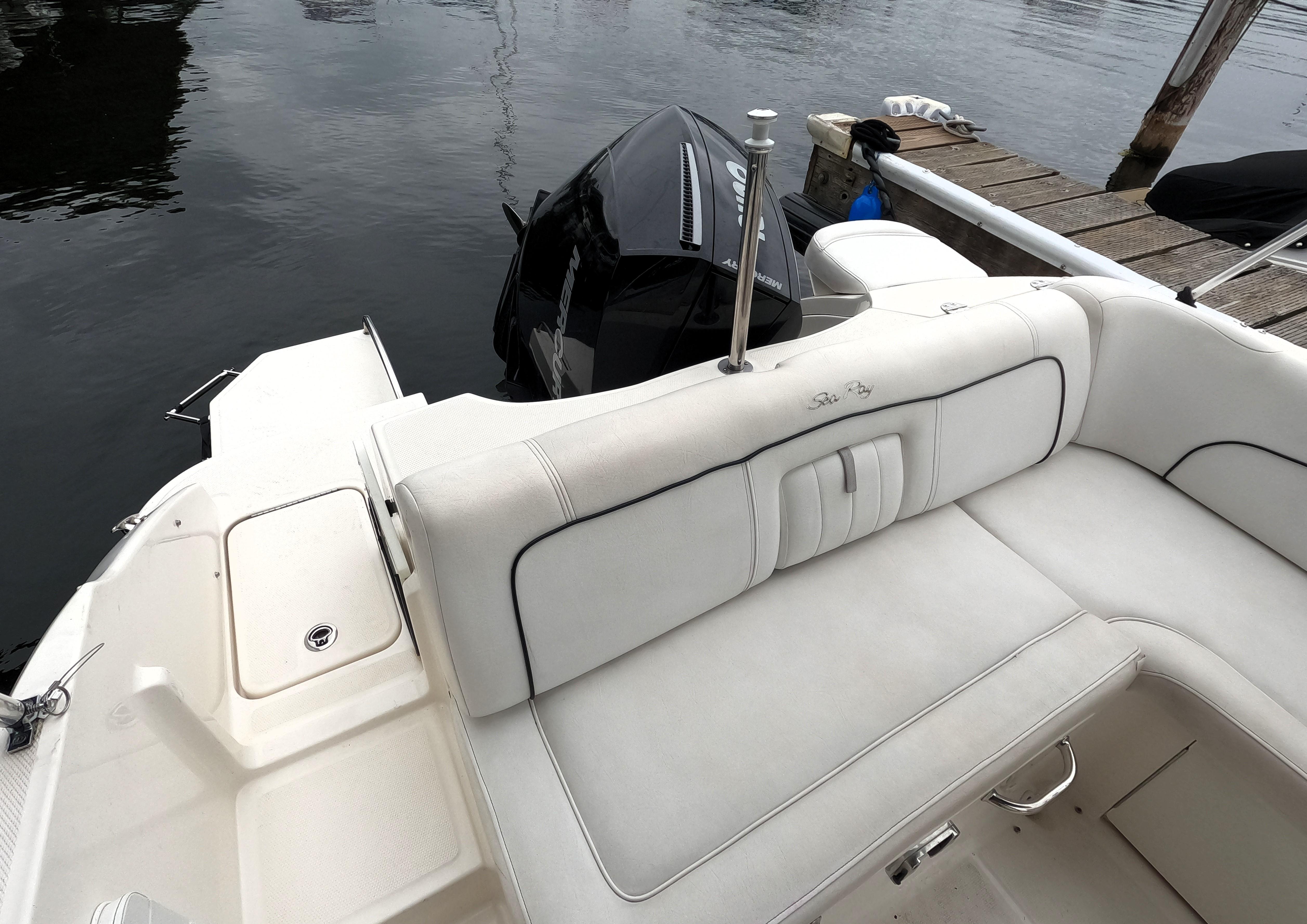 2014 Sea Ray 240 Sundeck Outboard boat with white seating and docked at marina.