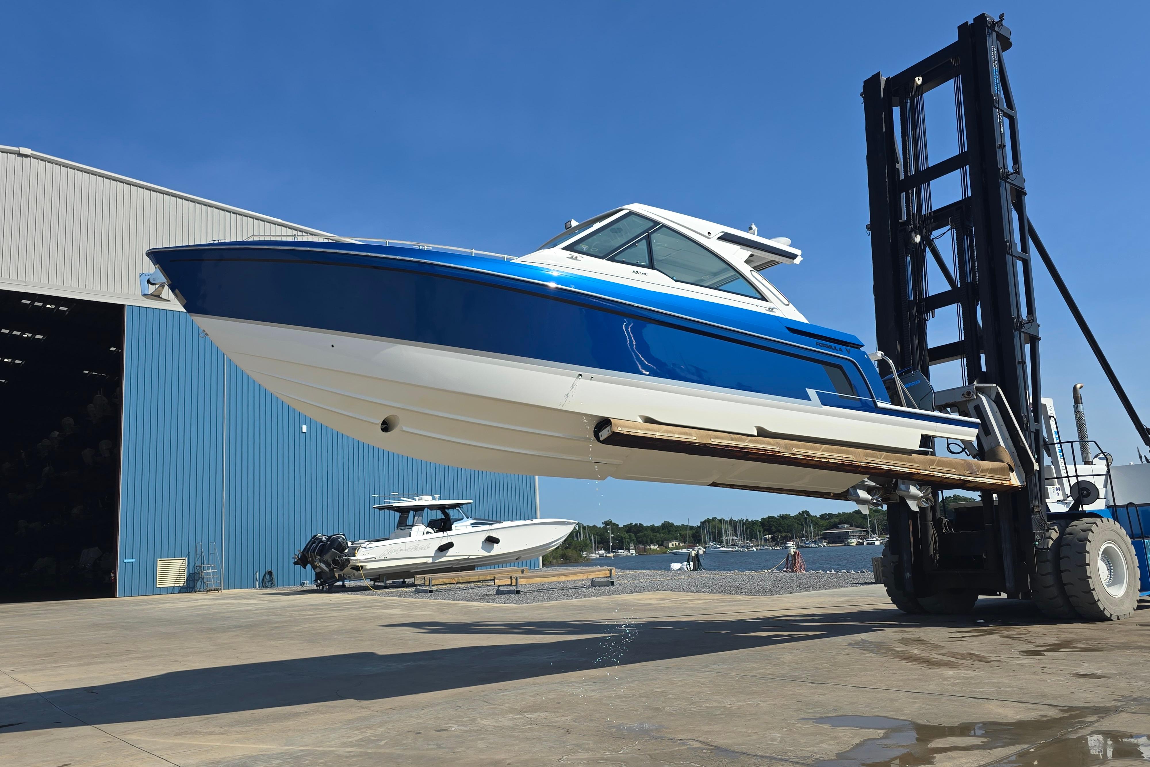 2025 Formula 380 Super Sport Crossover OB lifted by forklift near marina.