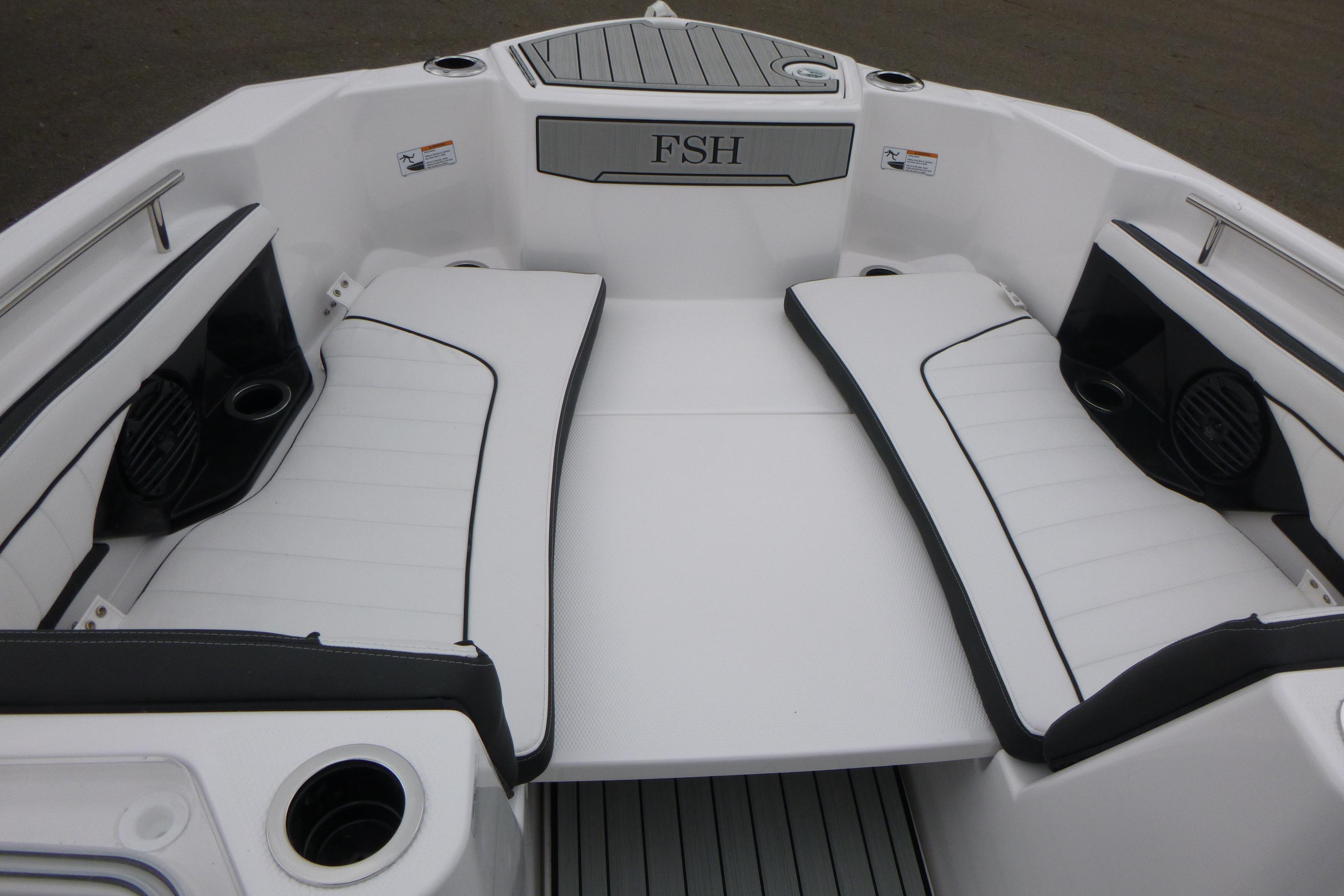 2026 Yamaha Boats 255 FSH Sport H interior with white cushioned seating and cup holders.