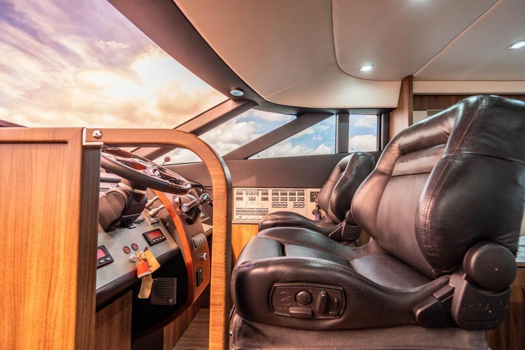 Luxurious interior of 2020 Fairline 68 yacht with leather seating and modern controls.