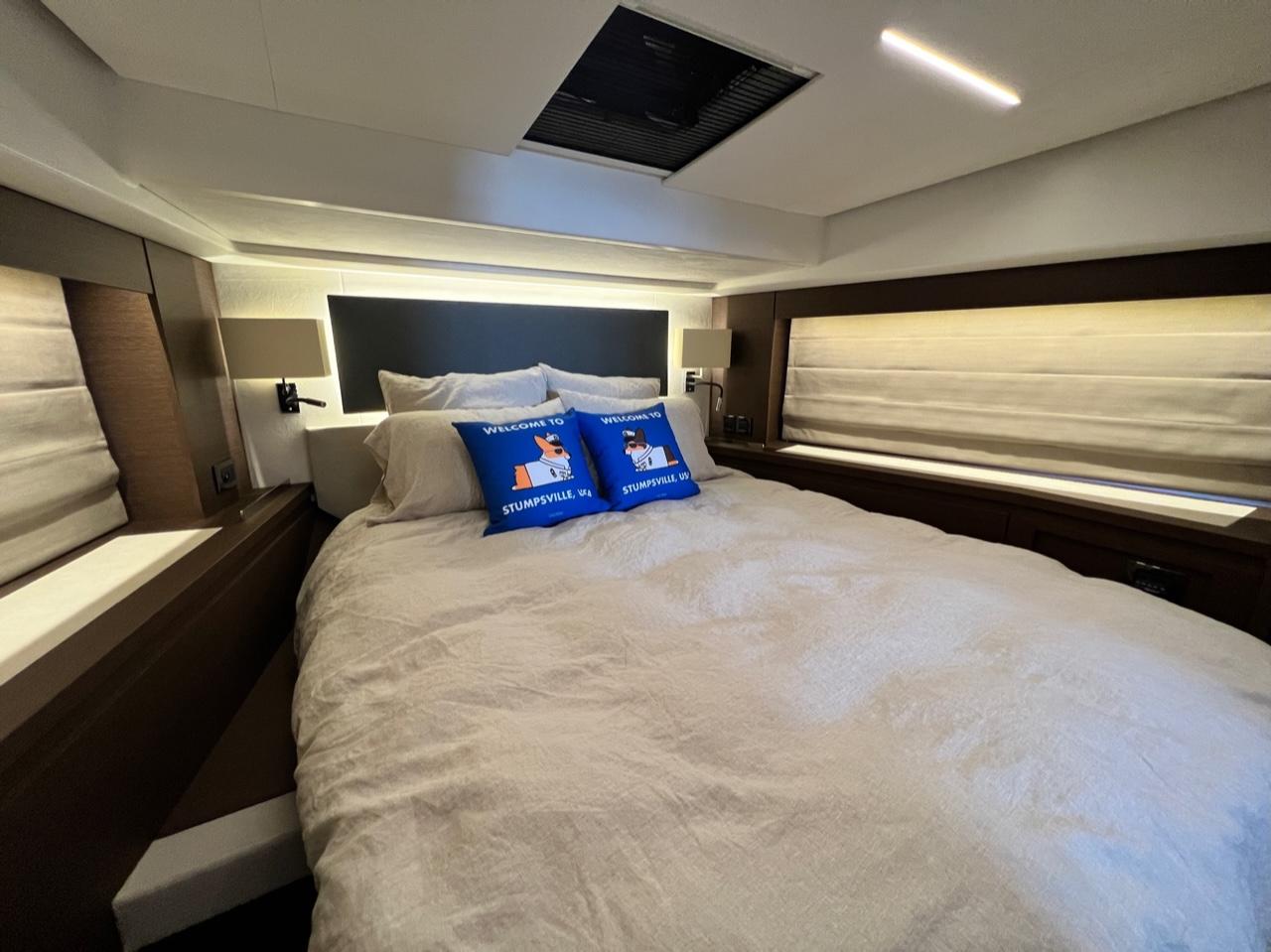 Luxurious bedroom interior of 2021 Prestige 590 Sport Fly yacht with cozy bedding.