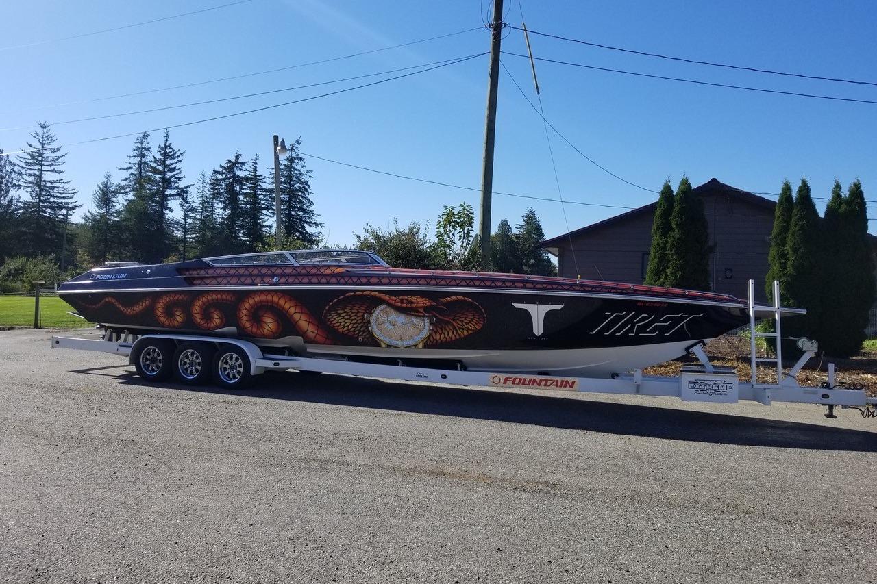 2004 Fountain 42 Lightning speedboat with snake design on trailer, parked outdoors.