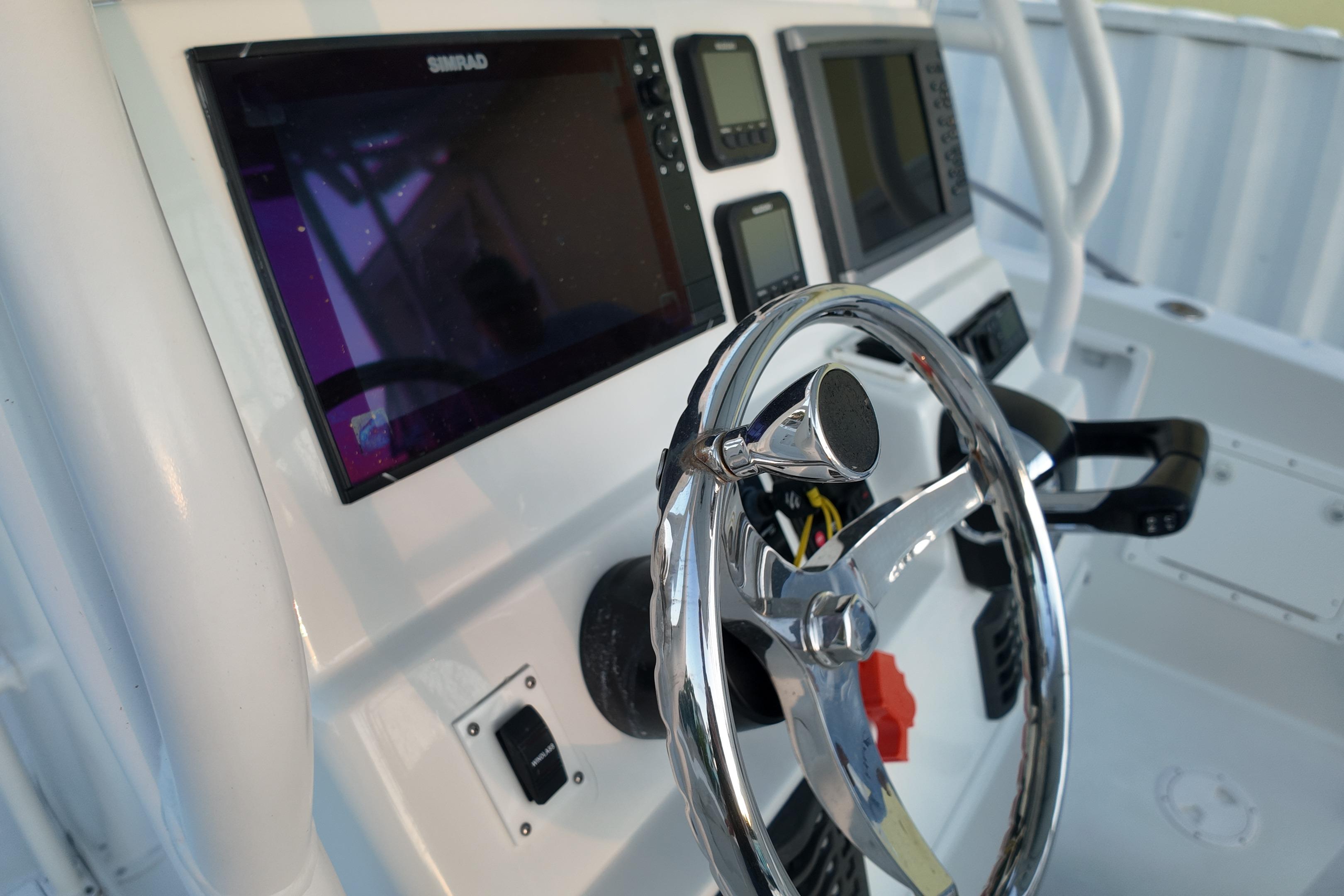 2003 Pro Sports 2860 SC ProKat boat dashboard with steering wheel and navigation screens.