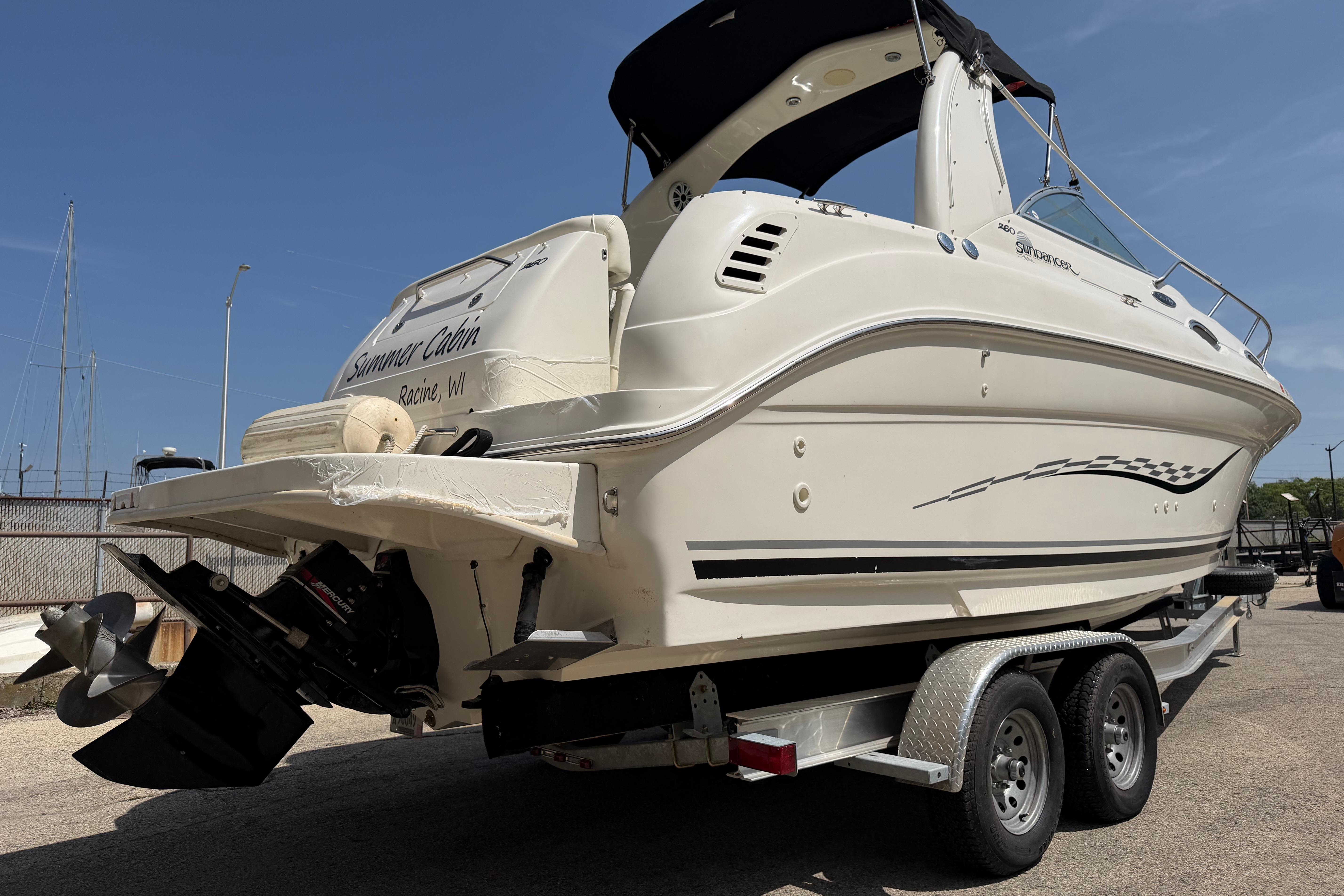 2004 Sea Ray Sundancer 260 boat on trailer, rear view, sunny day.