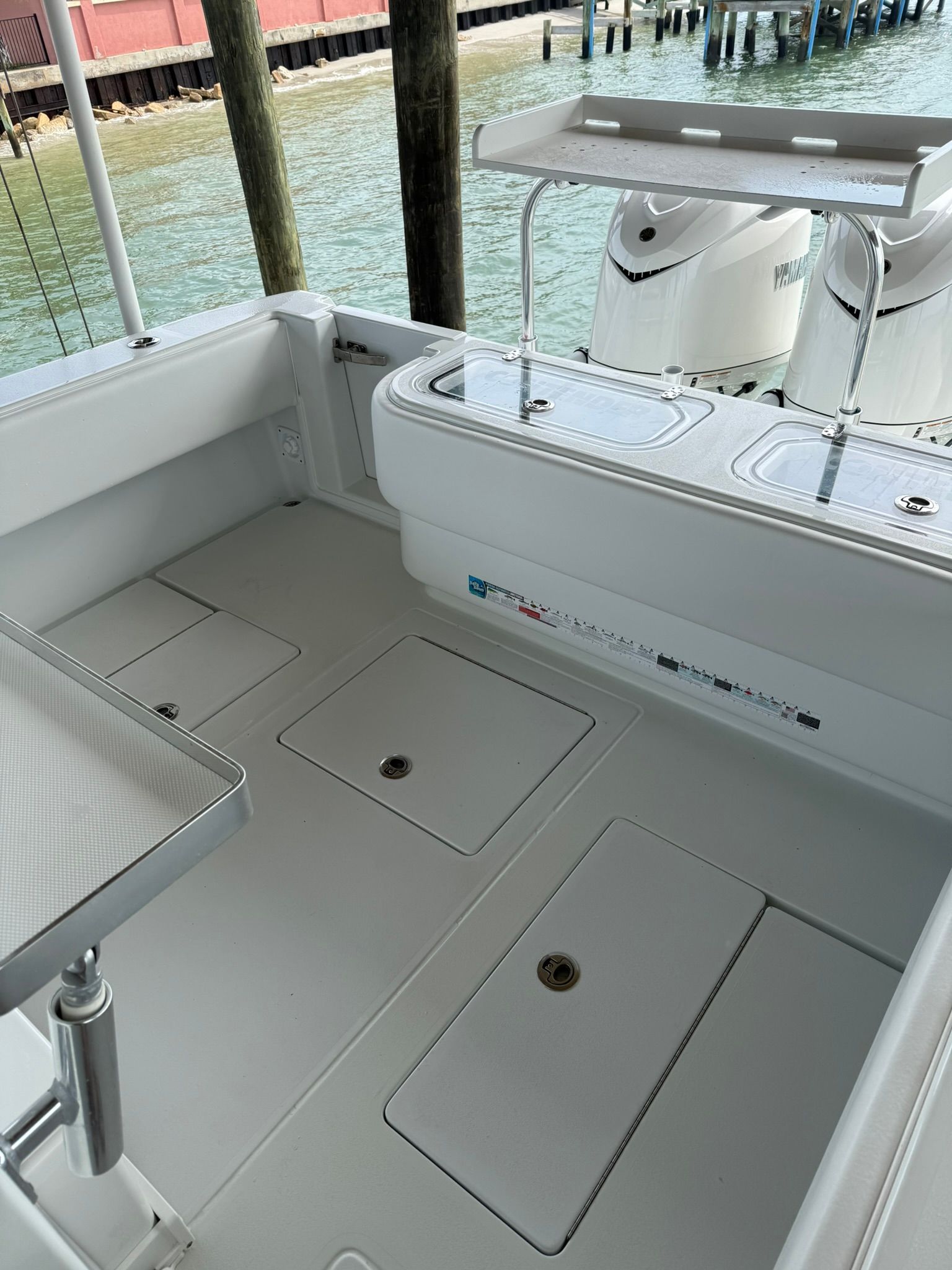 Interior of 2025 Contender 32 ST boat with storage and engines.