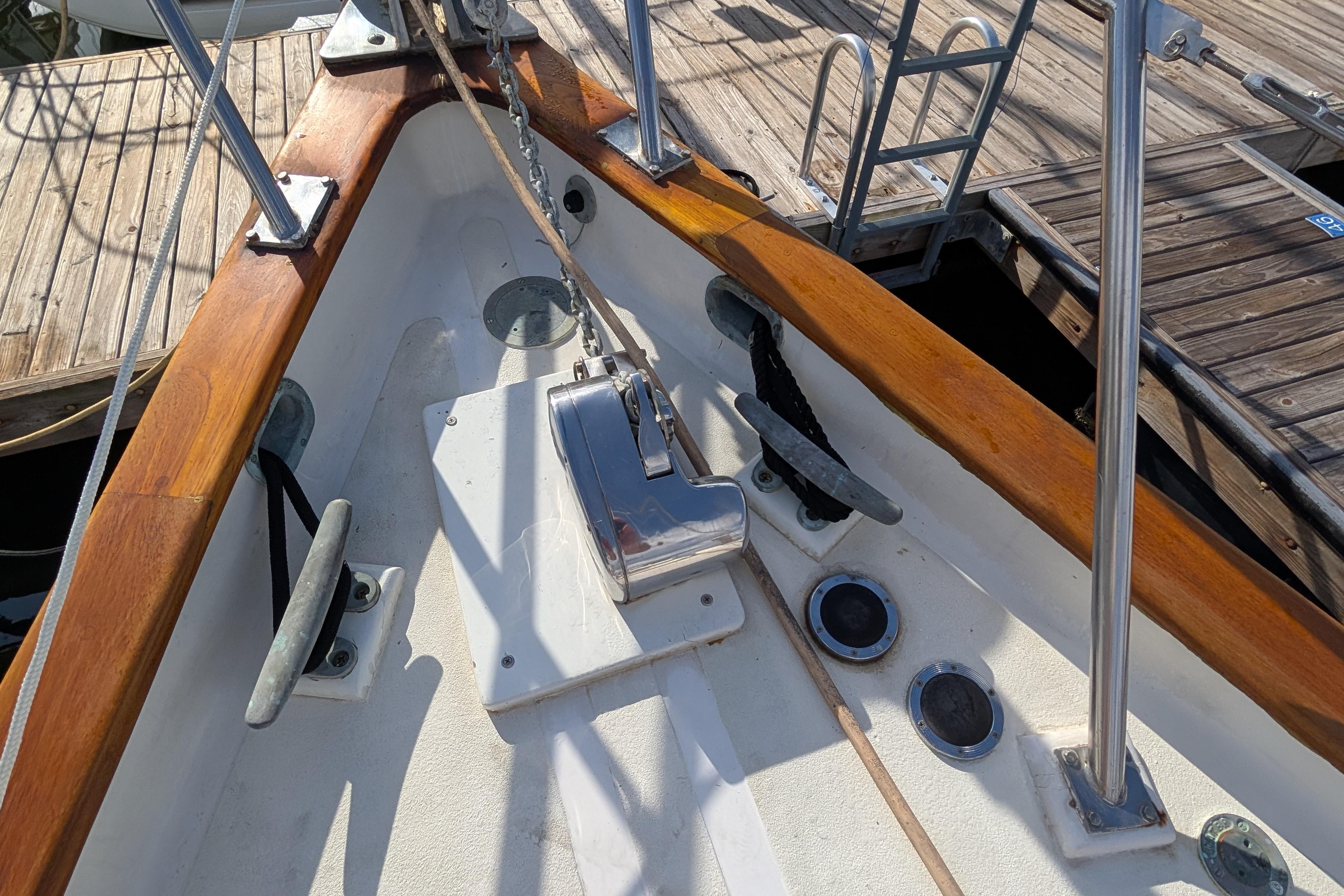Bow of 1983 Robert Perry 41 sailboat with anchor windlass and wooden trim.