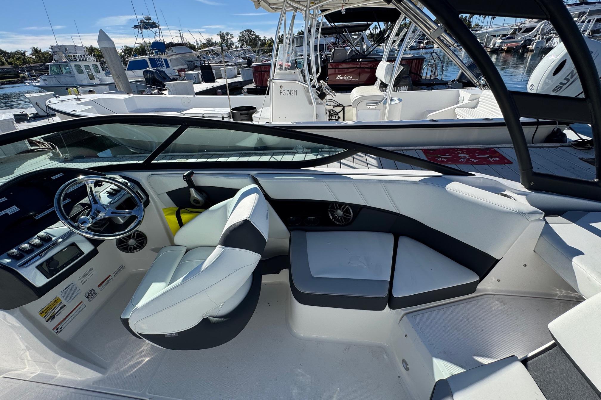 2026 Regal 21 OBX boat interior with modern seating and steering, docked at marina.