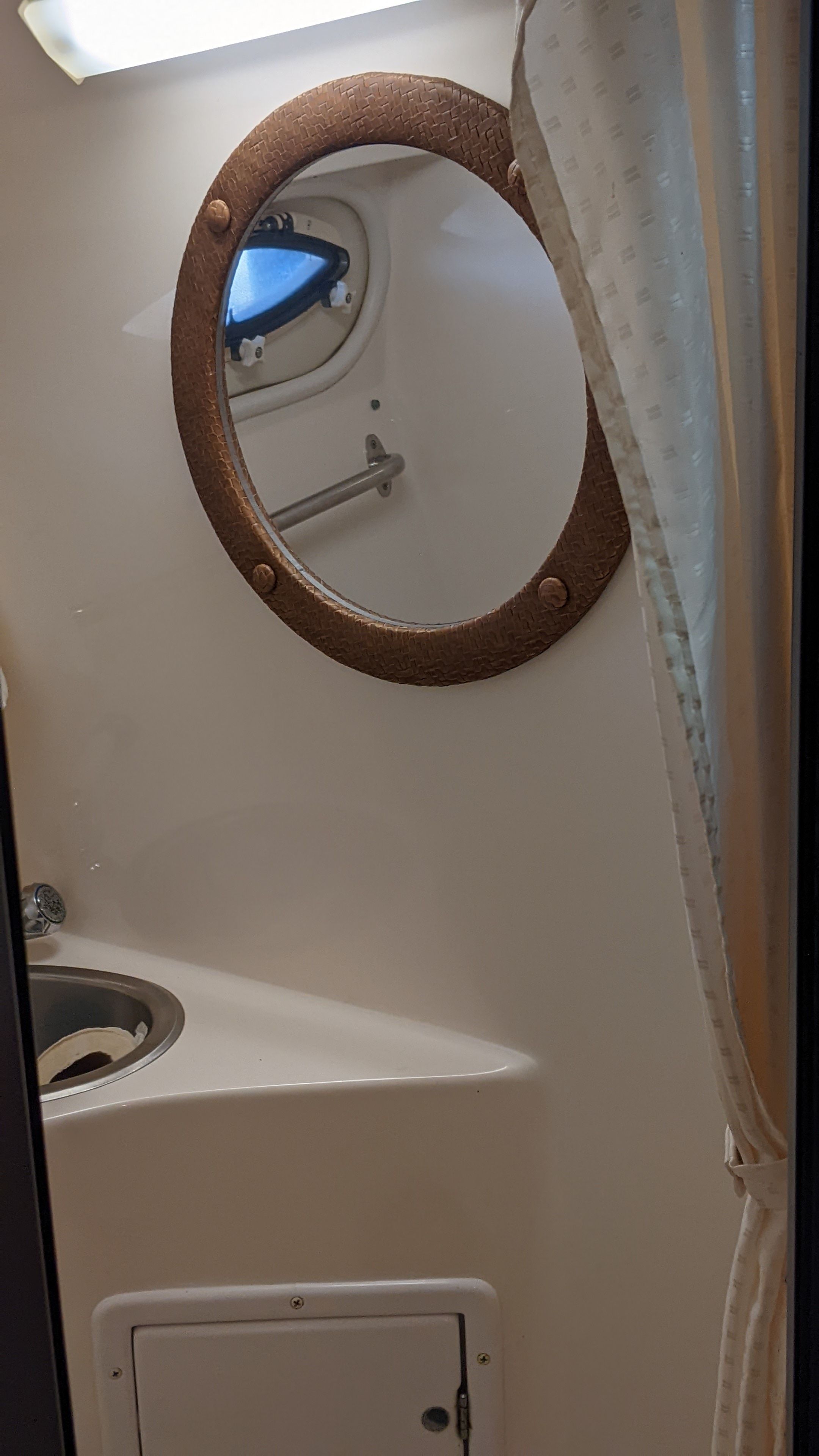 Interior of a 2006 Rinker 250 EC with porthole and sink.