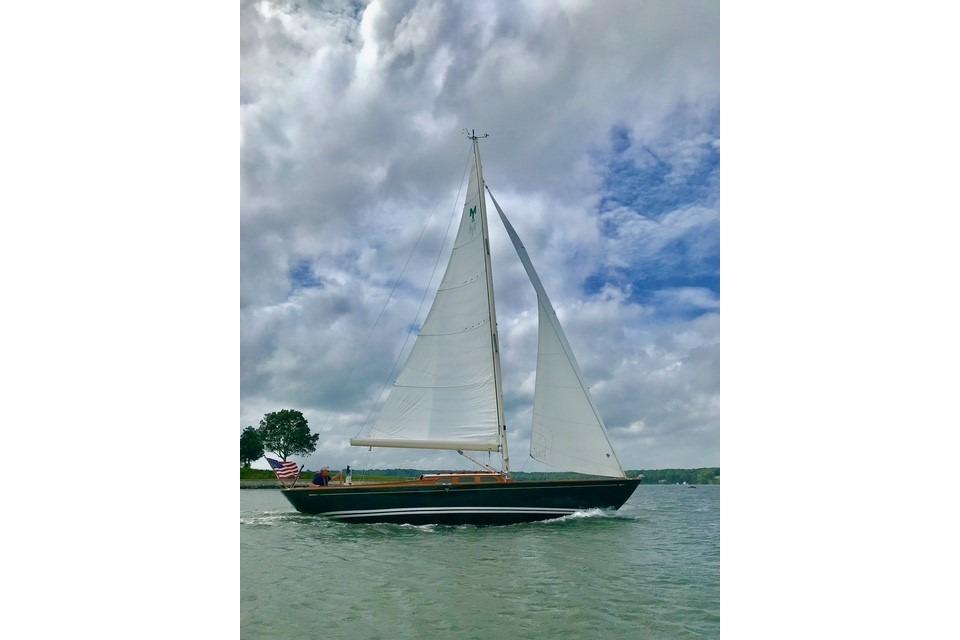 Sailing yacht Morris 36 (2006) gliding on water under cloudy sky.