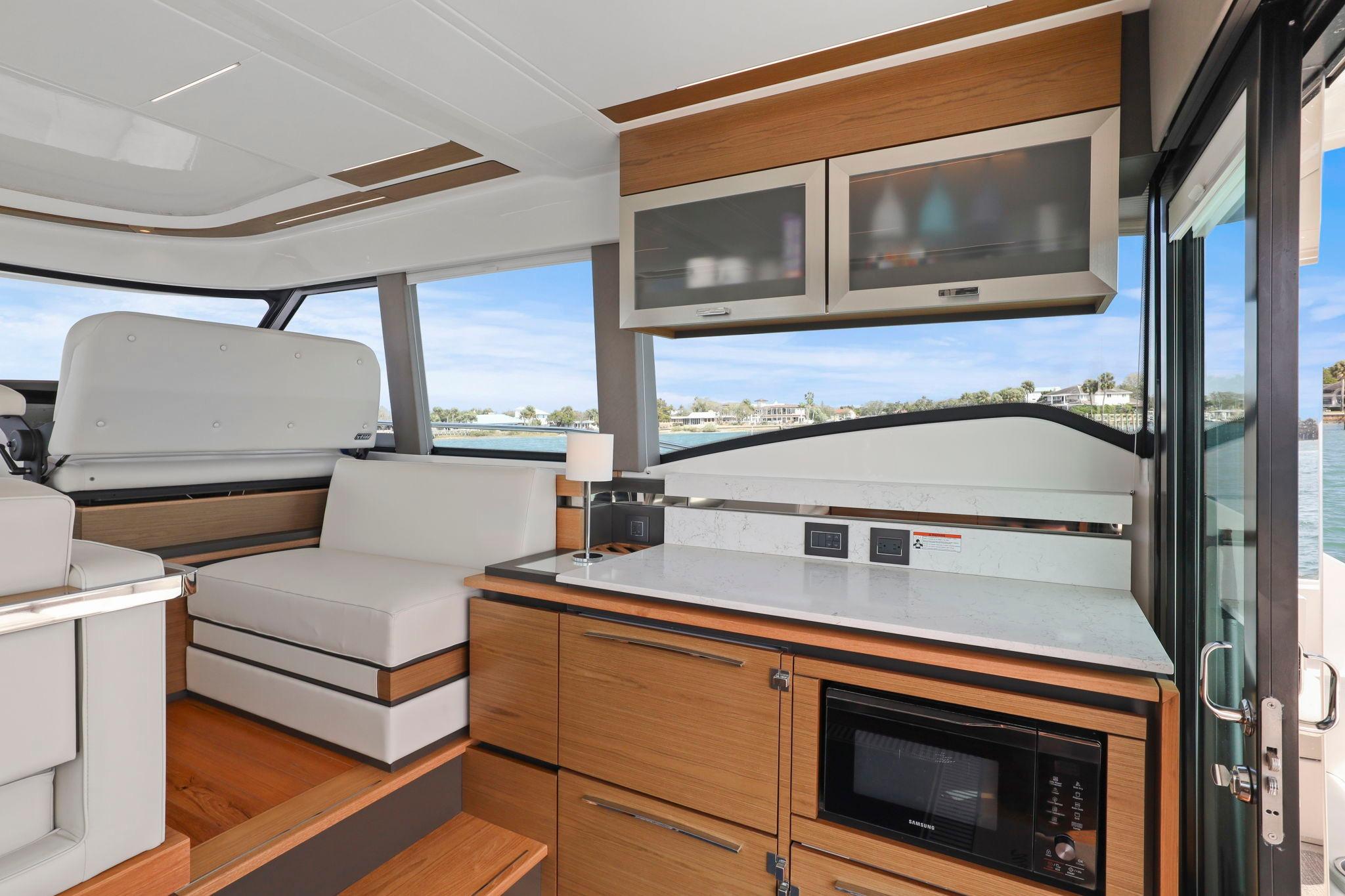 Luxurious interior of 2023 Tiara Yachts C49 Coupe with modern kitchen and seating area.