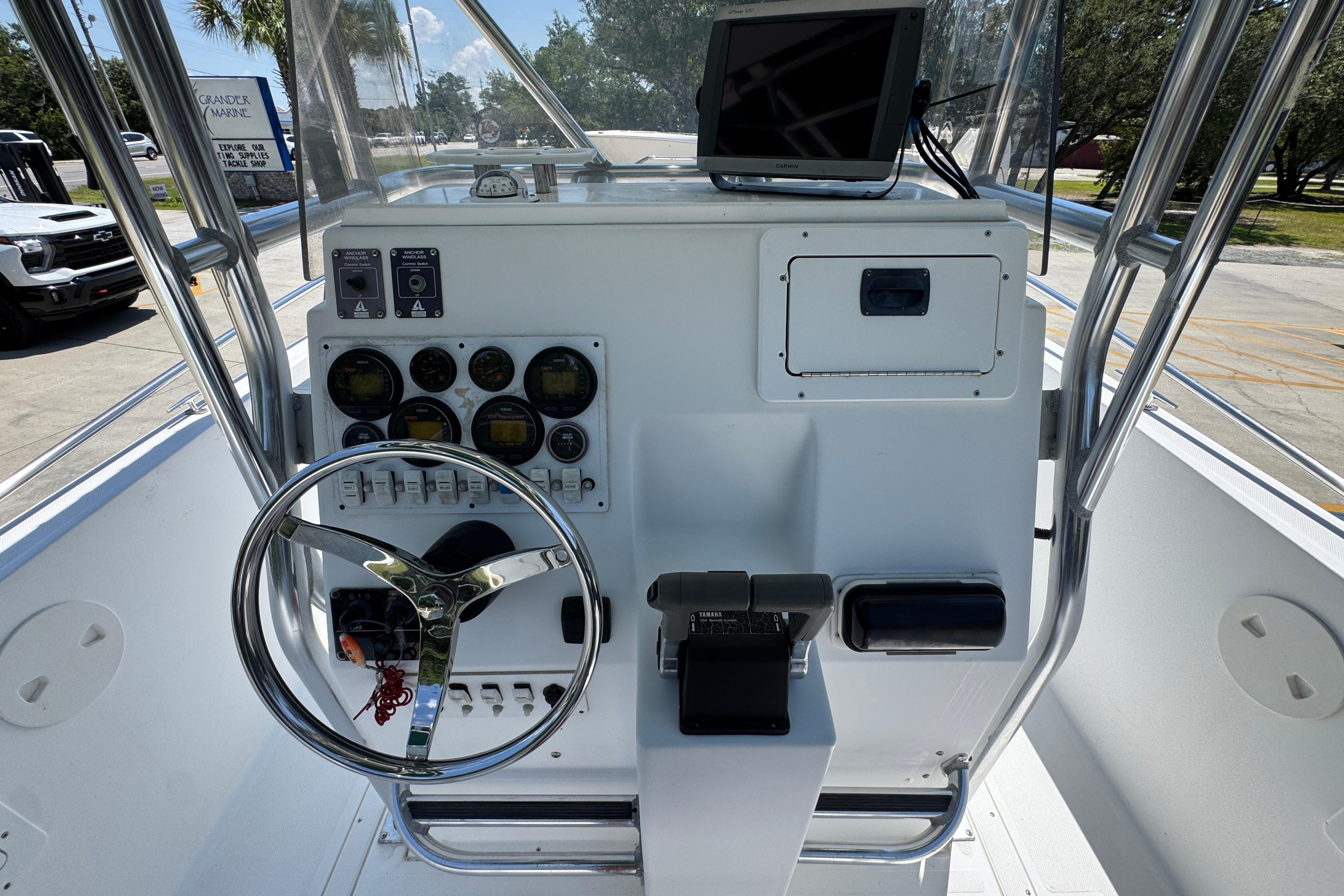 Center console of a 2000 Stamas 250 Tarpon boat with steering wheel and gauges.