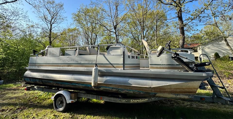 2005 Playbuoy Tropic 20' pontoon boat on trailer outdoors.