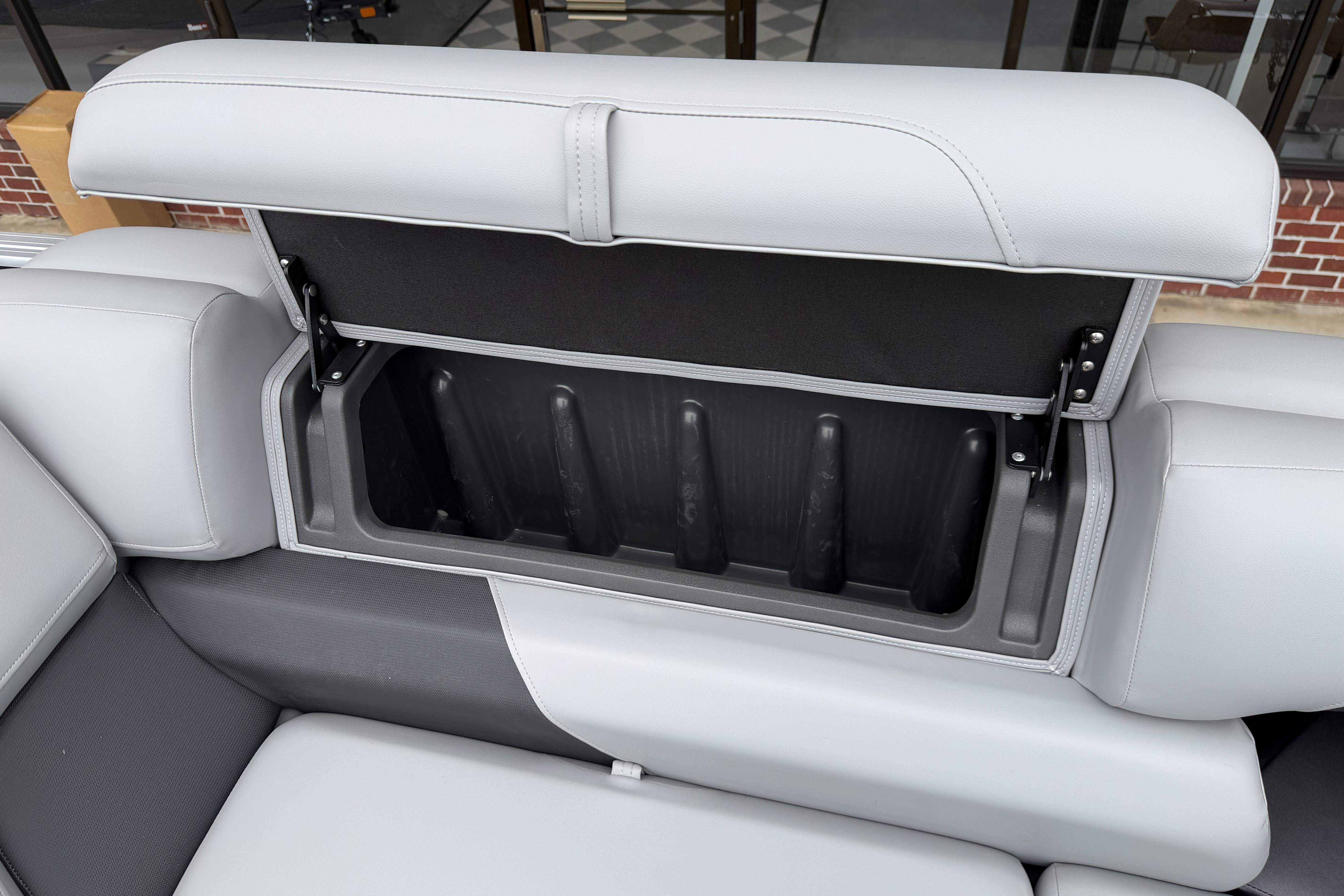 2026 Sun Tracker Party Barge 20 DLX storage compartment with open cushioned seat.