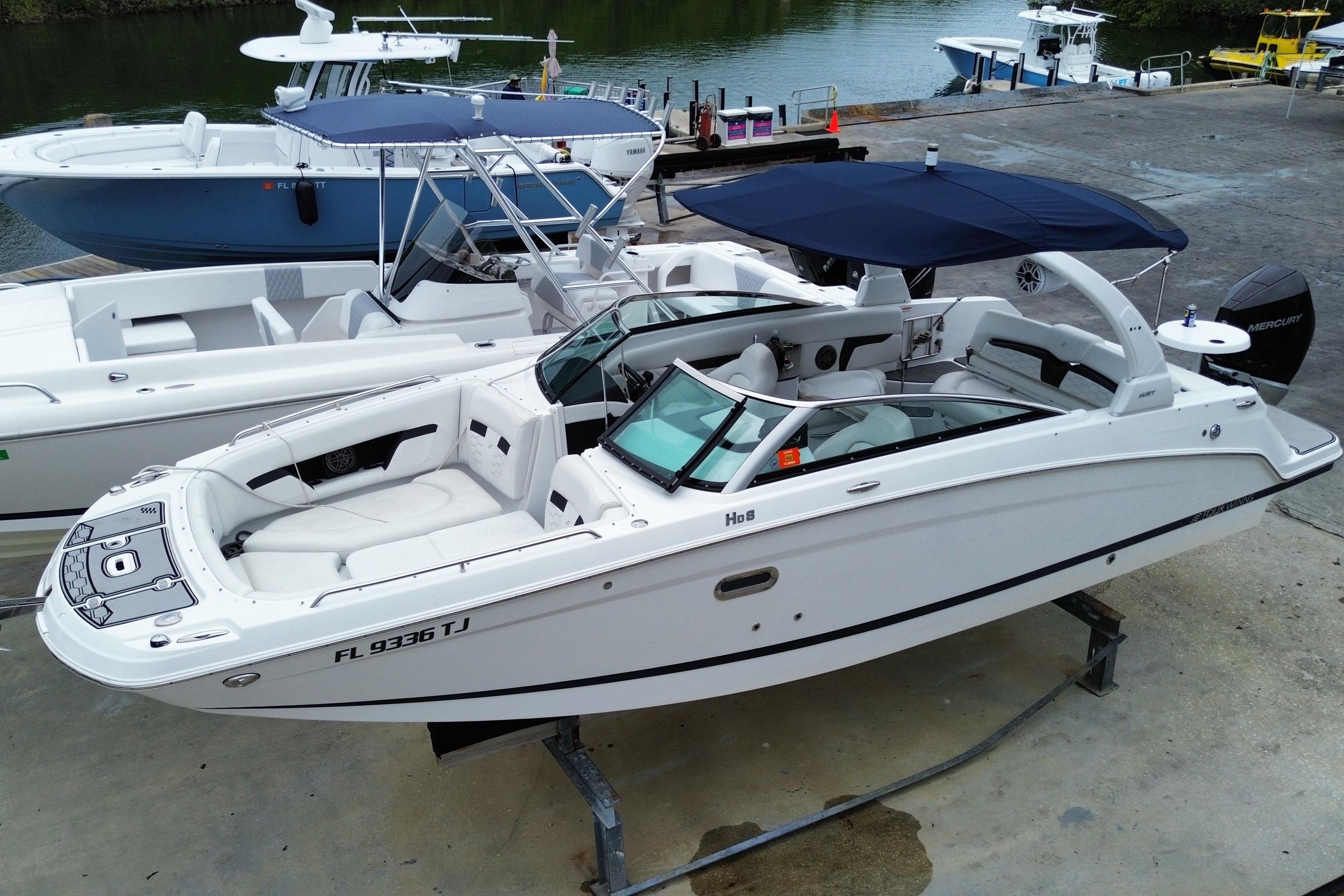 2022 Four Winns HD8 OB boat docked, featuring sleek design and spacious seating.
