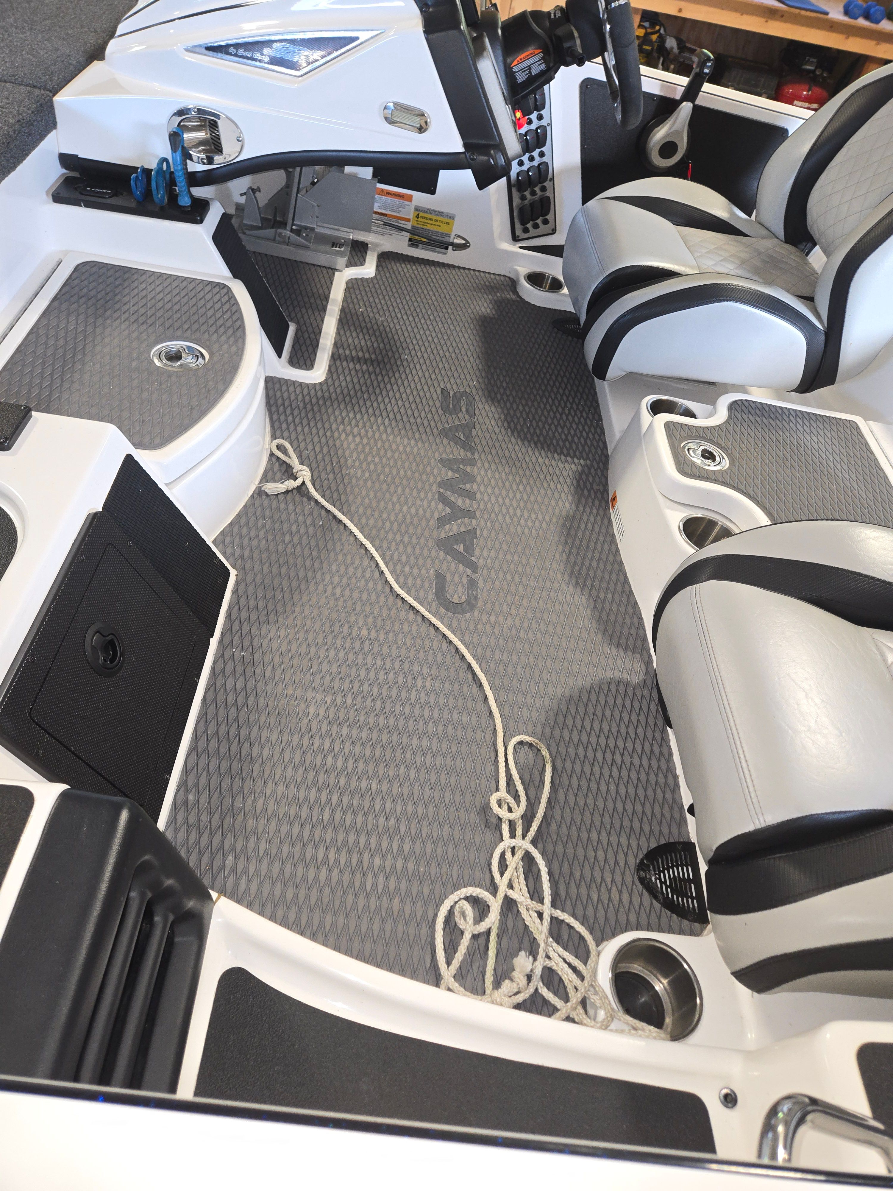Interior of a Caymas CX 19 boat with gray flooring and white seats.